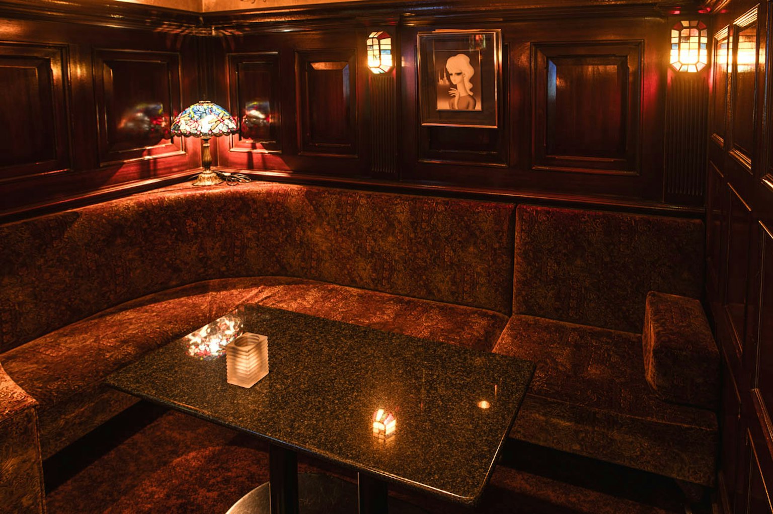 Intérieur de bar confortable avec murs en bois, sièges moelleux, une table et des lampes élégantes