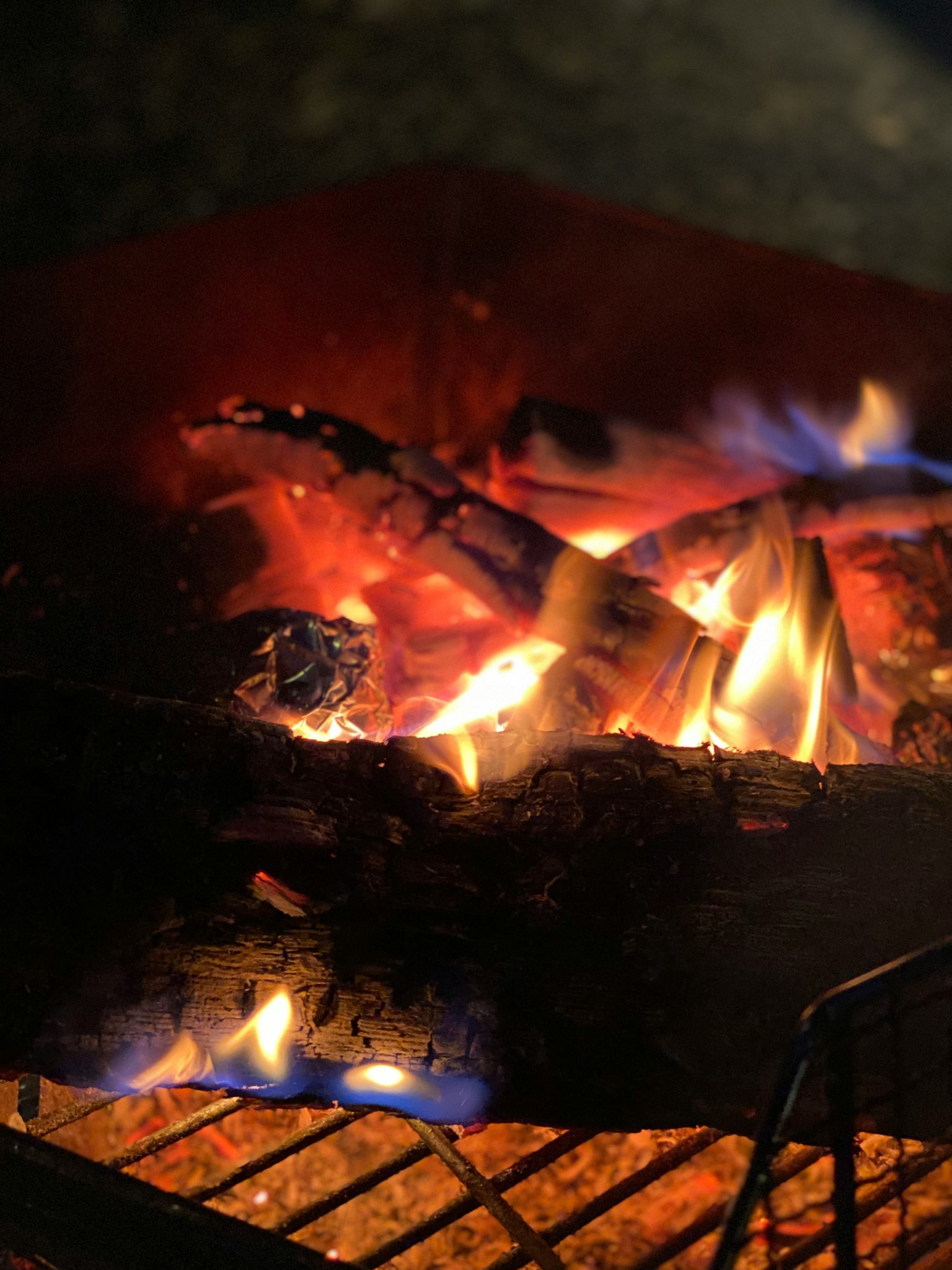Gros plan sur des bûches brûlantes dans un feu de camp avec des flammes vives
