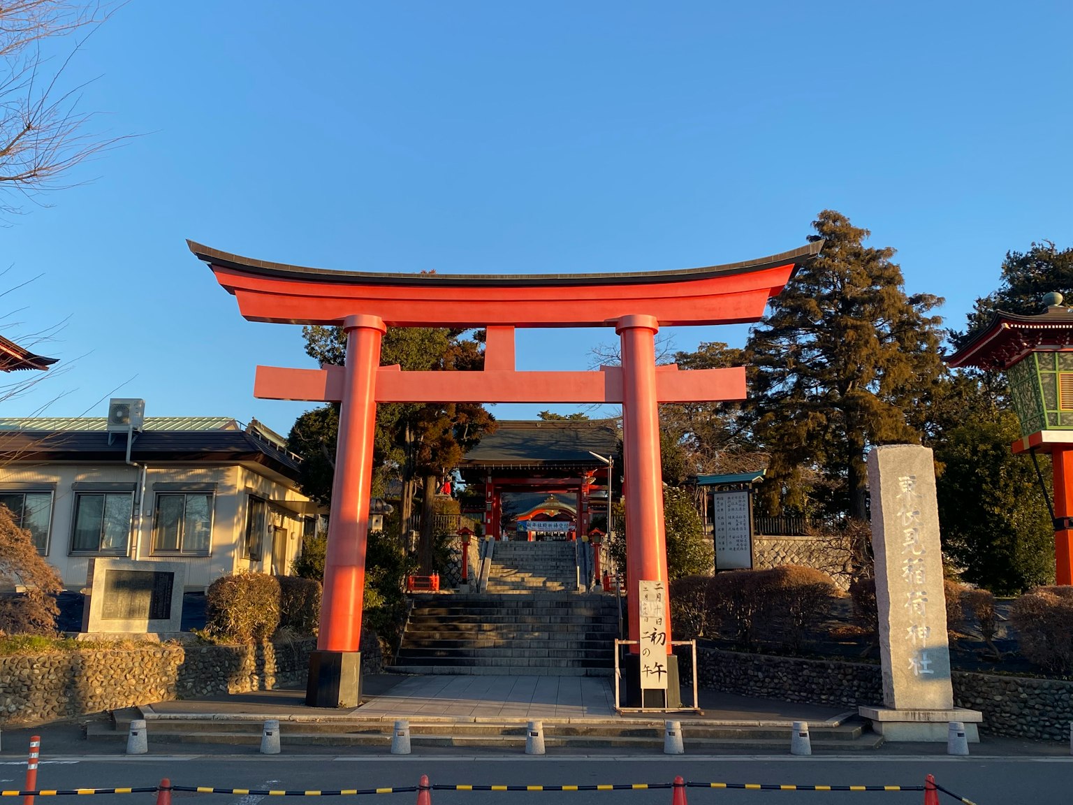 Entrance of a shrine with a red torii gate under a blue sky