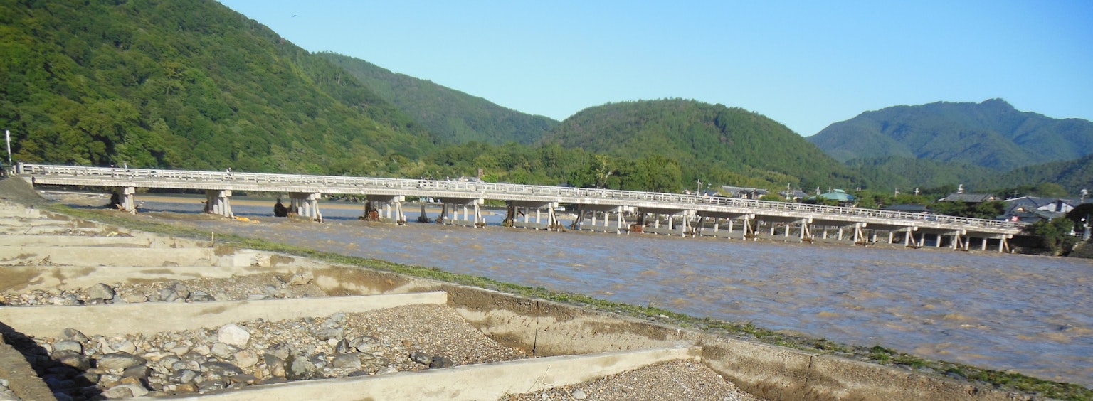 Vista escénica de un río con un puente y montañas