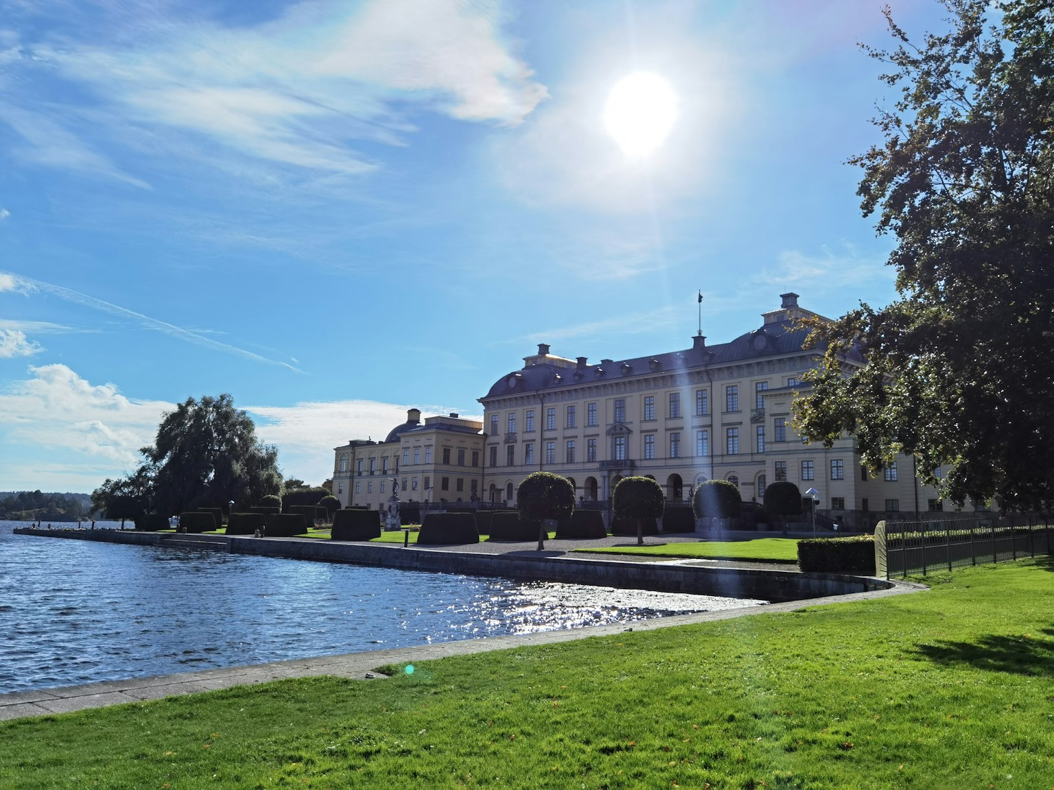 Bâtiment historique au bord d'un lac serein sous un ciel bleu éclatant