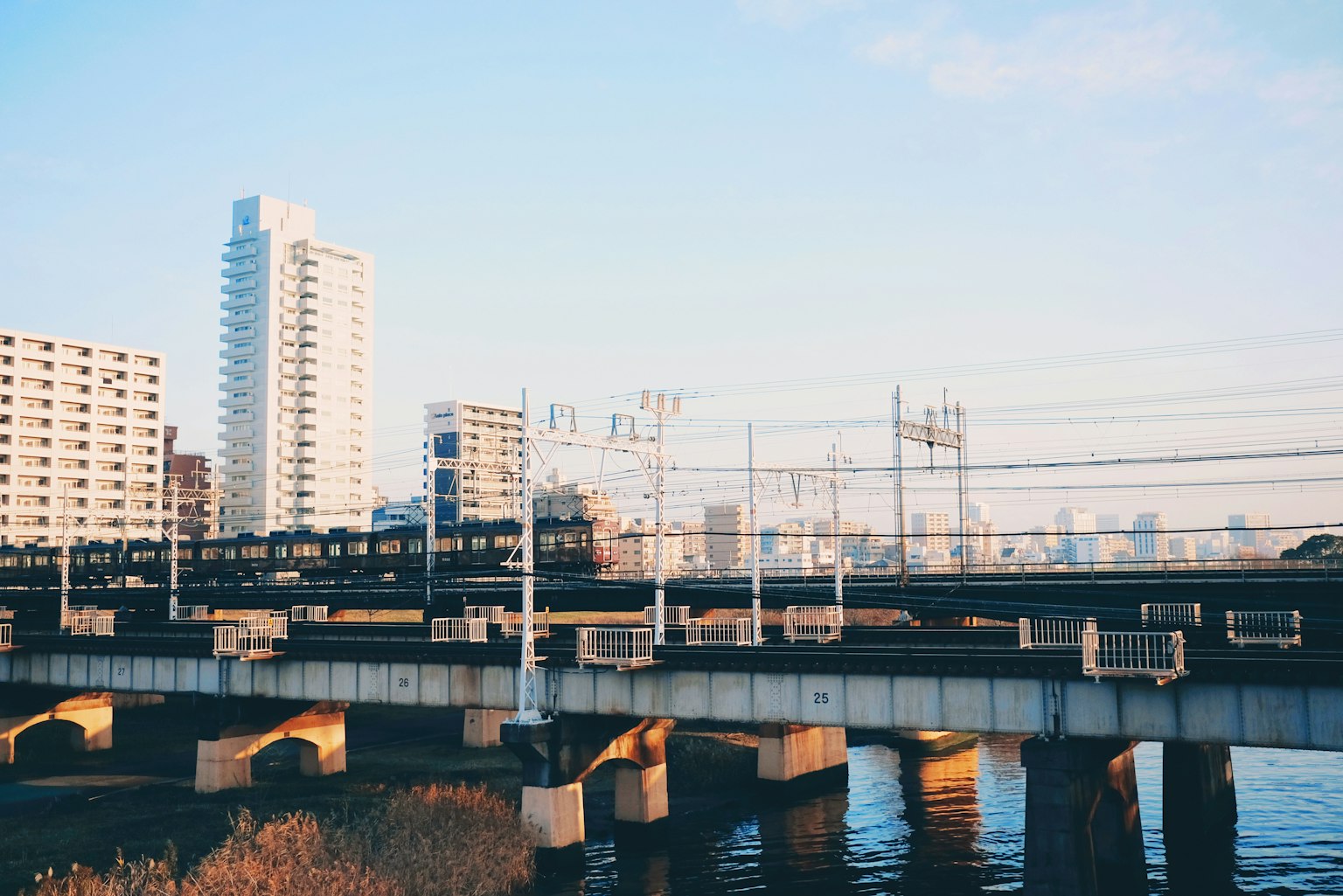 Paysage urbain avec un pont ferroviaire sur une rivière et des bâtiments en arrière-plan