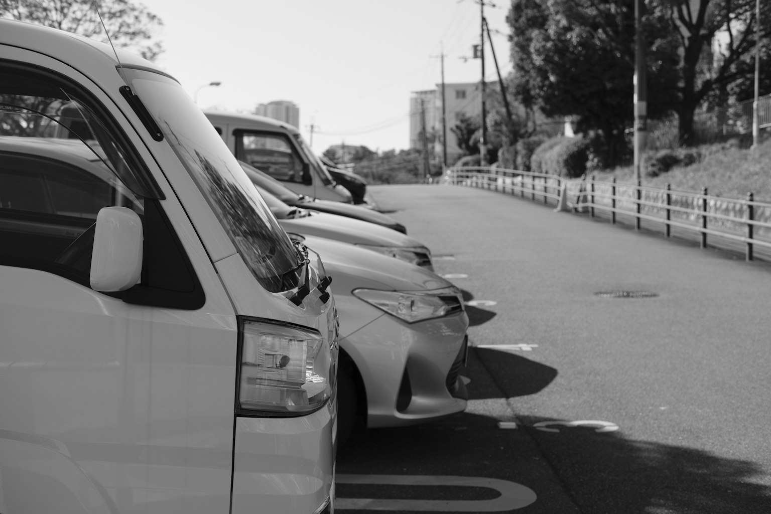 Several cars parked in a black and white parking lot