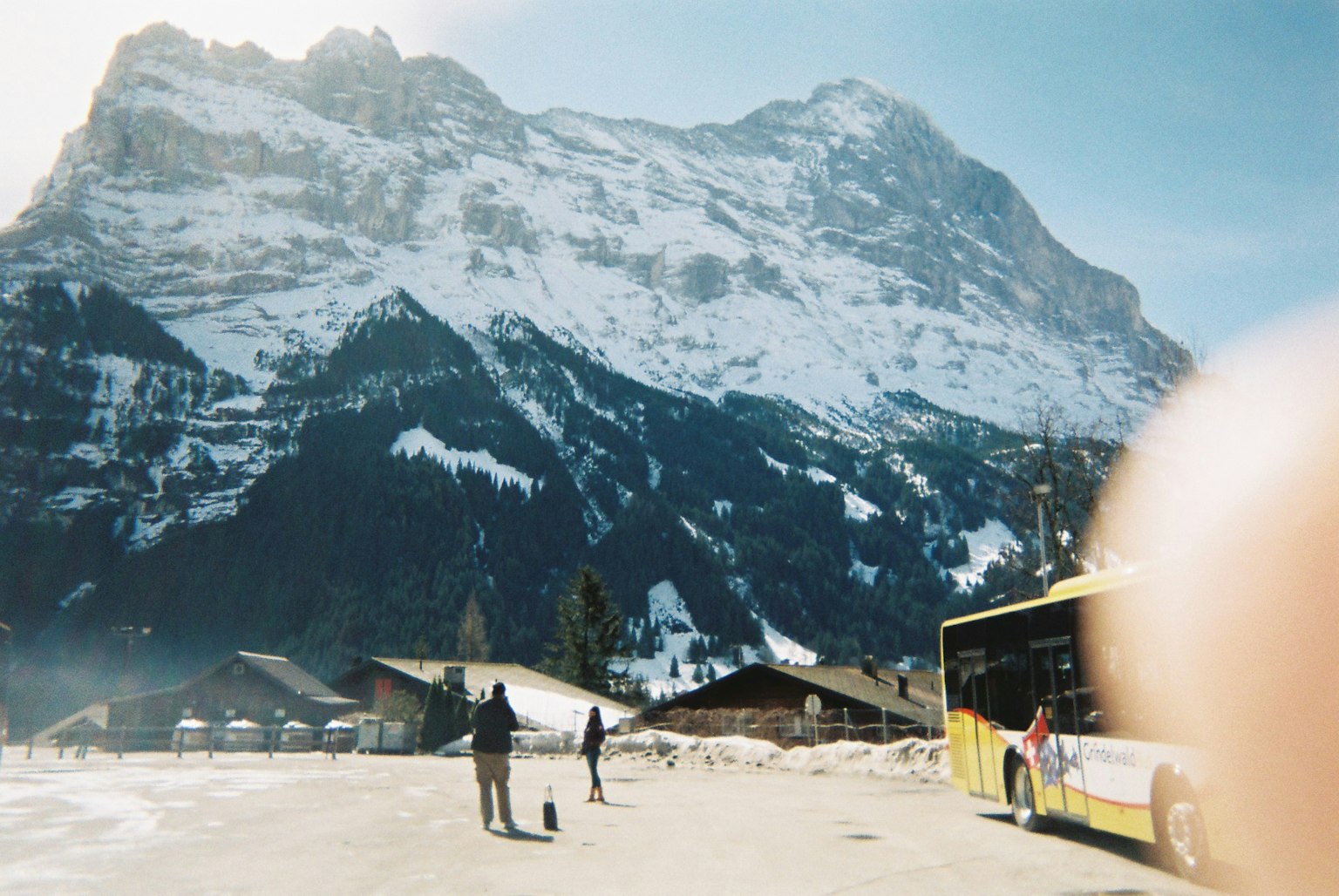 Persone in piedi vicino a un autobus di fronte a montagne innevate