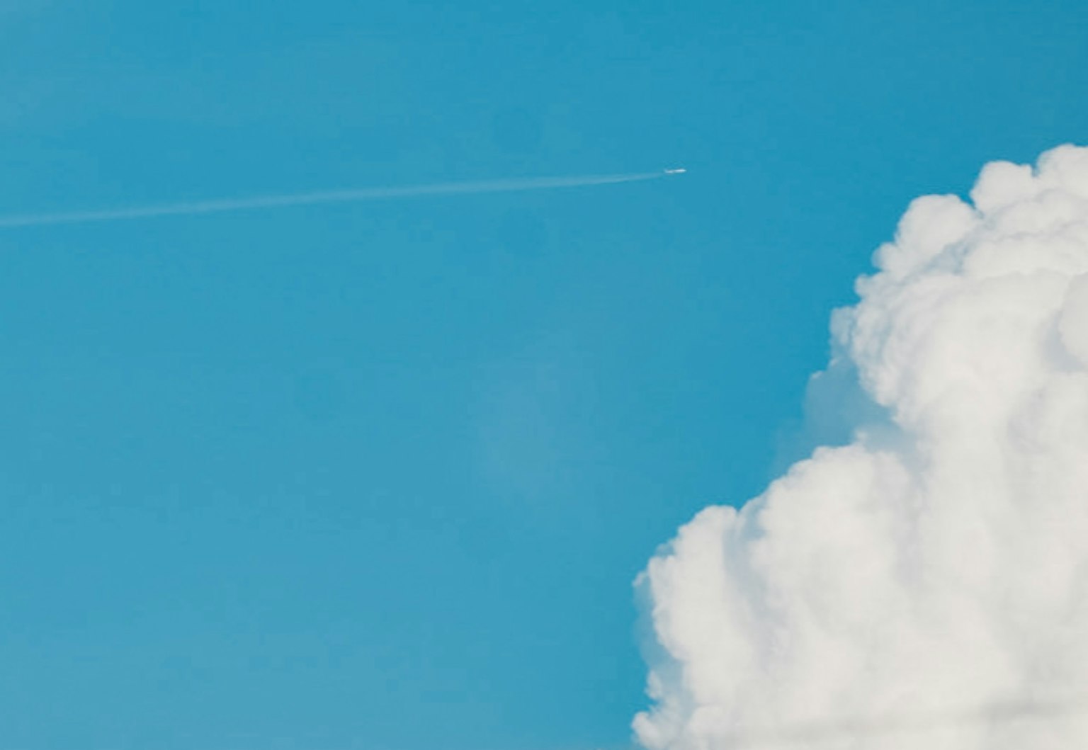 青空に浮かぶ白い雲と飛行機雲