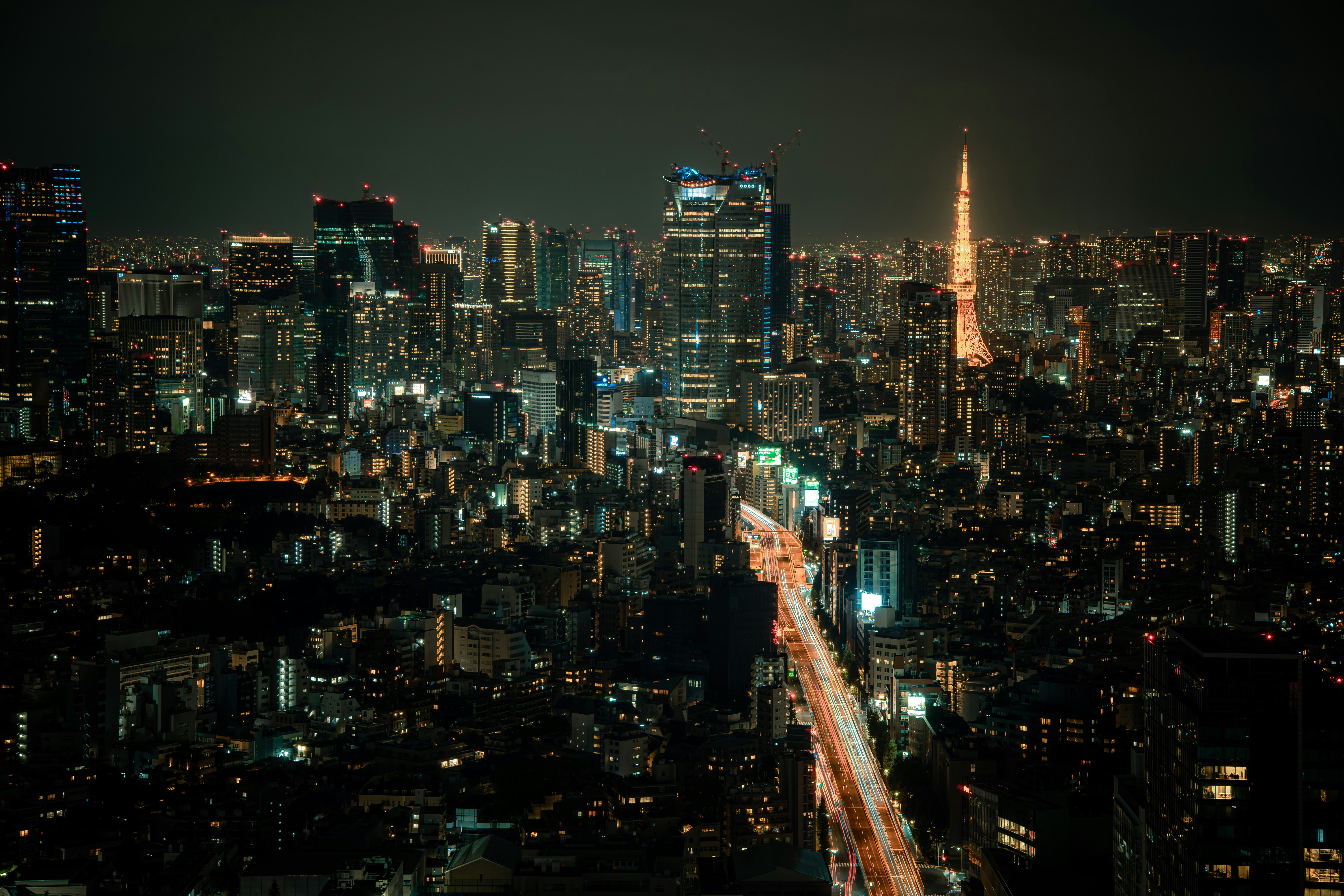 Horizonte nocturno de rascacielos densos con luces de la ciudad y una torre al centro