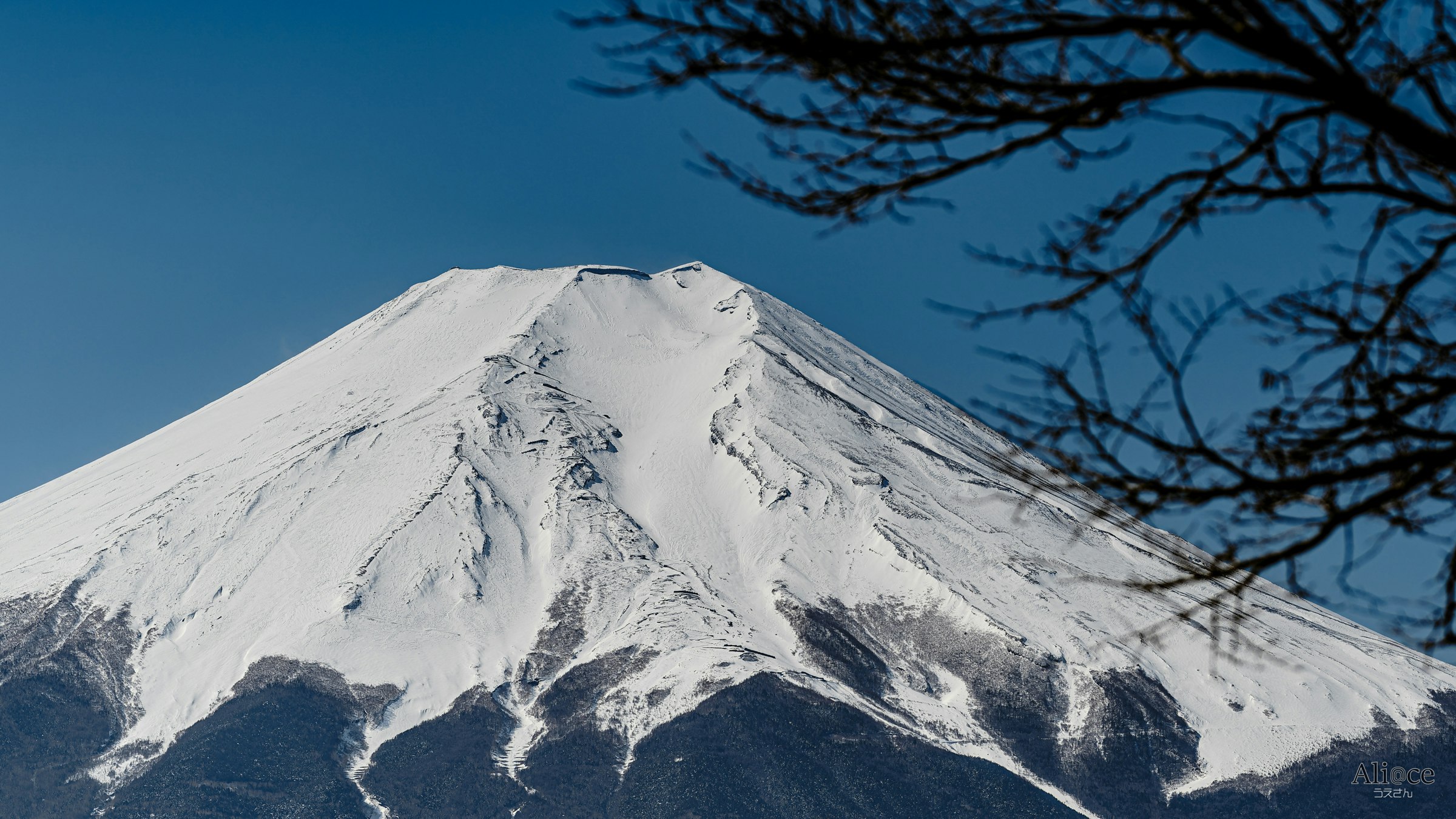 青空の下で雪をかぶった山の峰