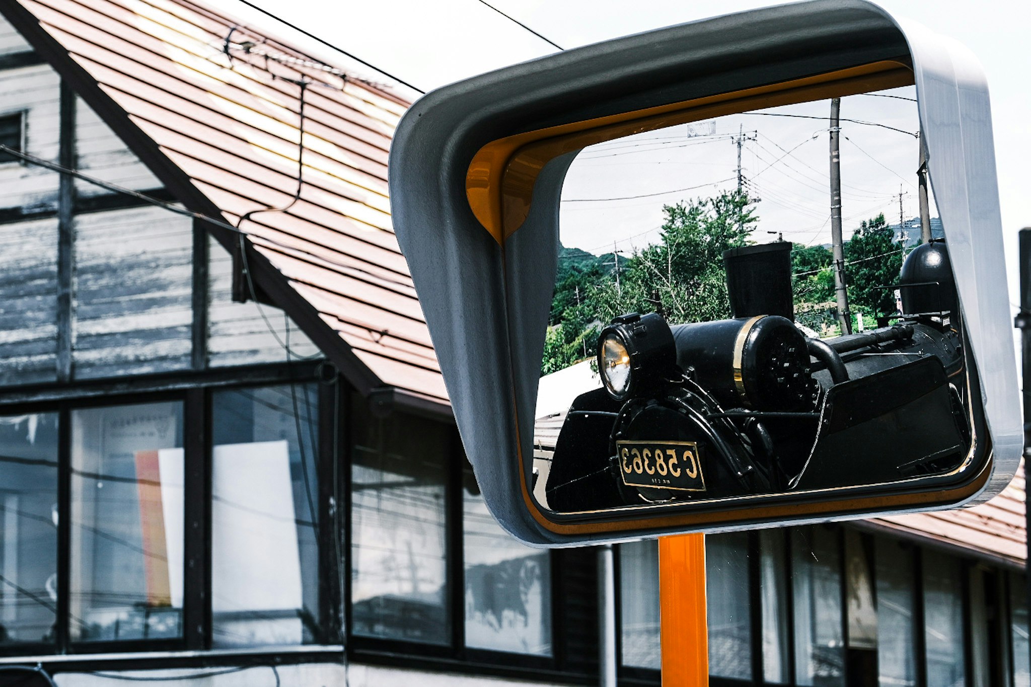 Locomotiva a vapore vista attraverso uno specchietto montato su un edificio esterno