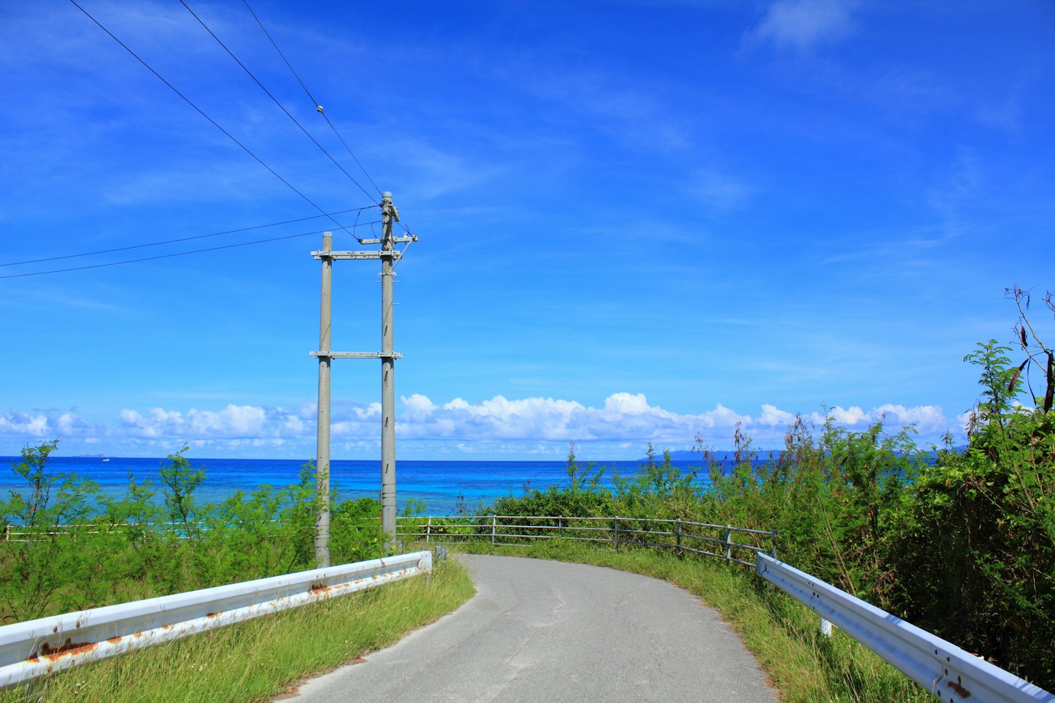 Strada curva con vista sul cielo blu e sull'oceano