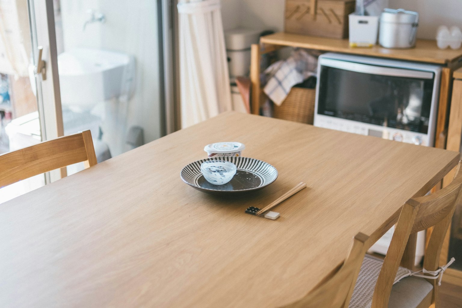 Simple dining table with a wooden surface featuring a Japanese plate and chopsticks