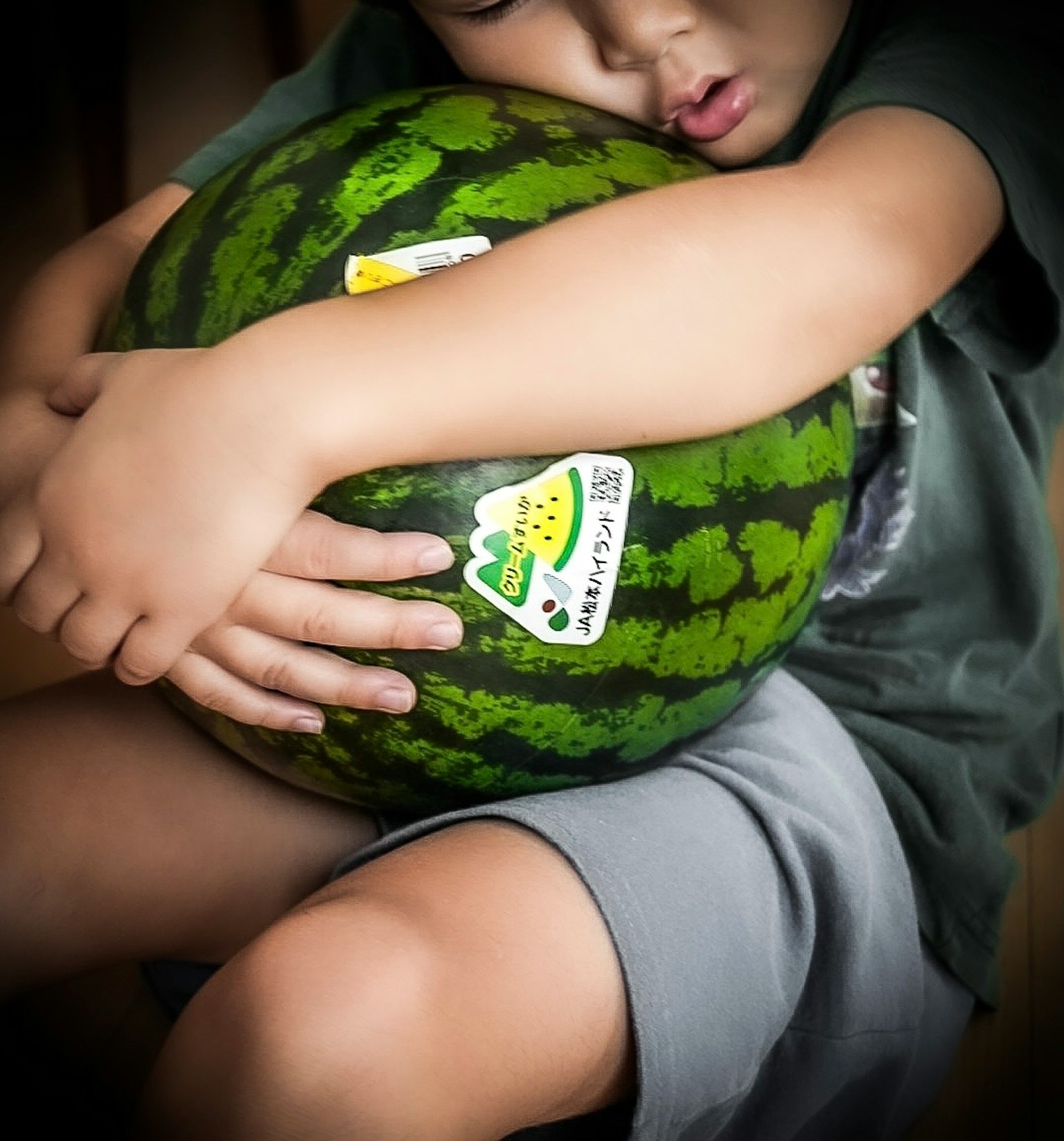Ein Kind umarmt eine Wassermelone mit Aufklebern