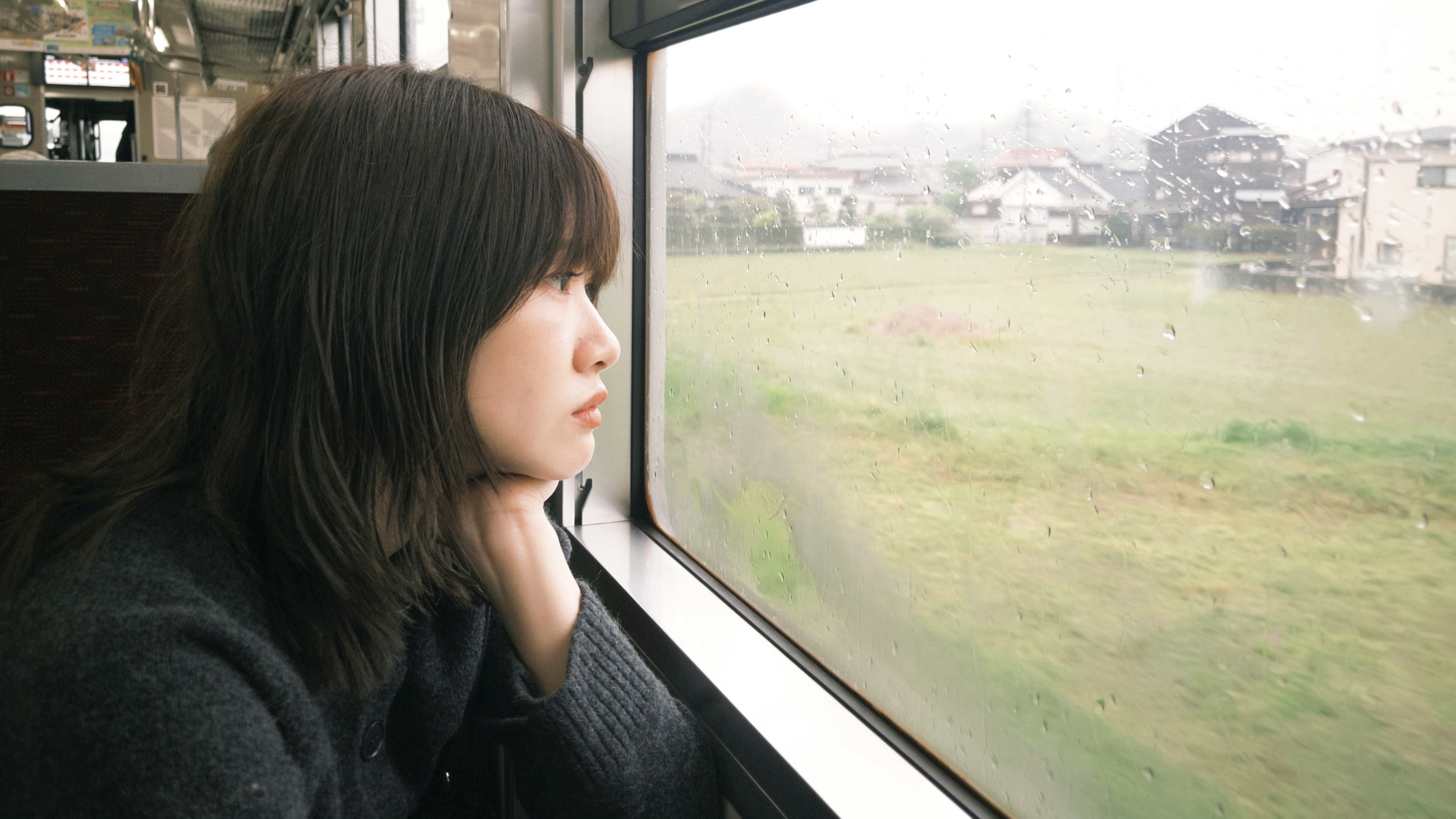 窓辺で外の景色を見つめる女性の横顔