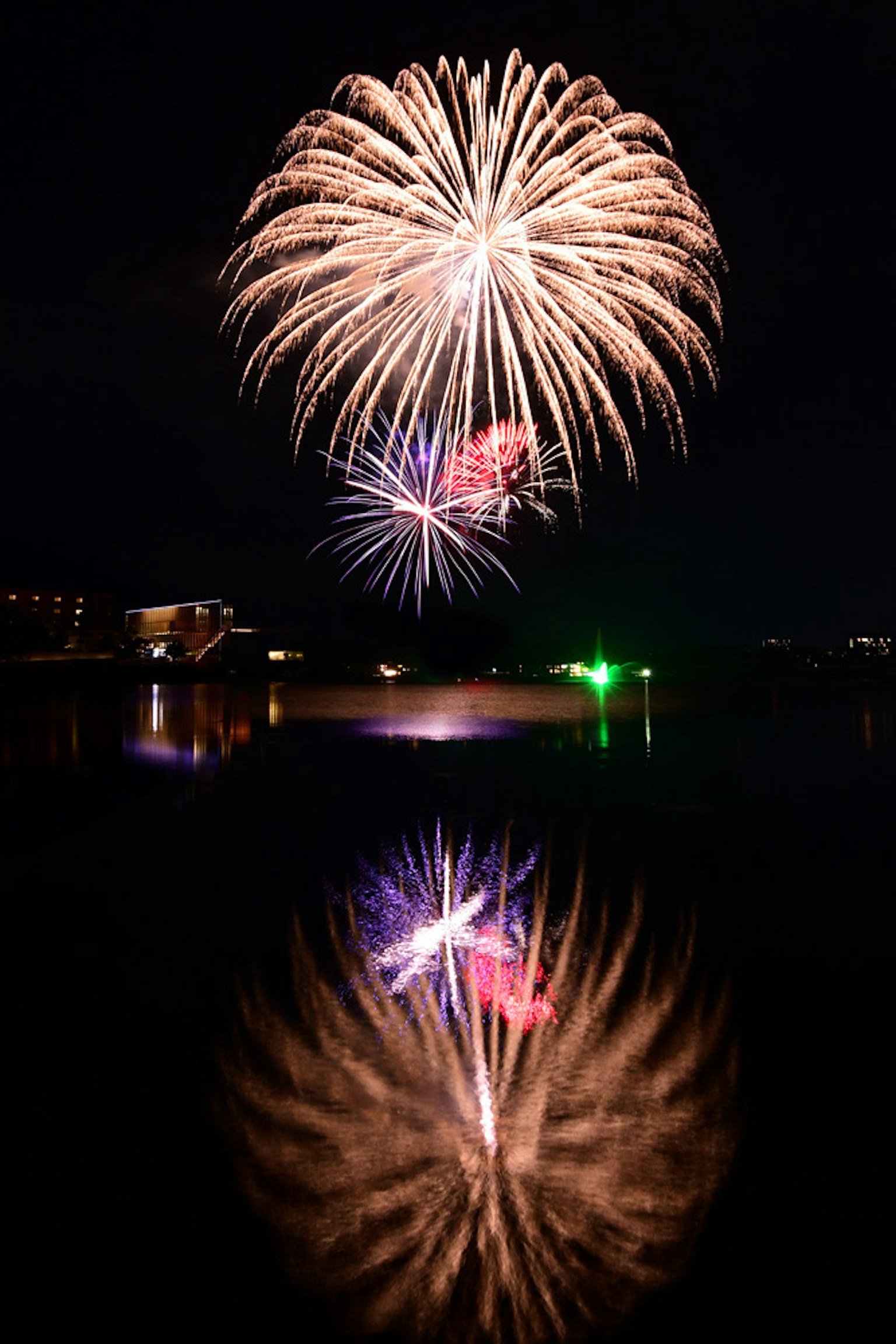 Beautiful fireworks display in the night sky colorful lights reflecting on the water