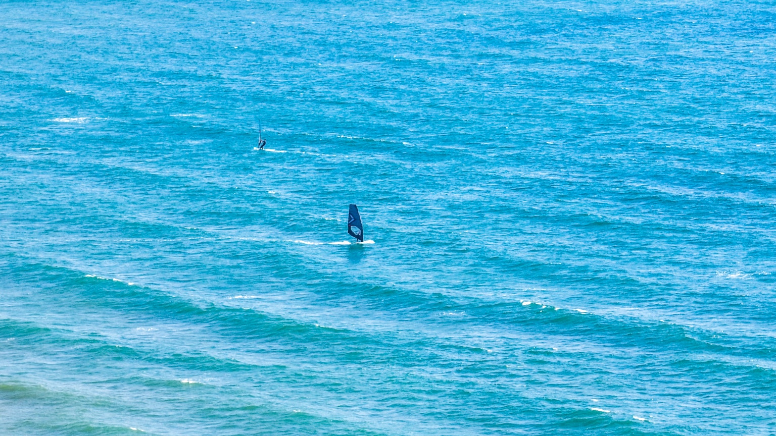 Un velero en un océano azul con suaves olas