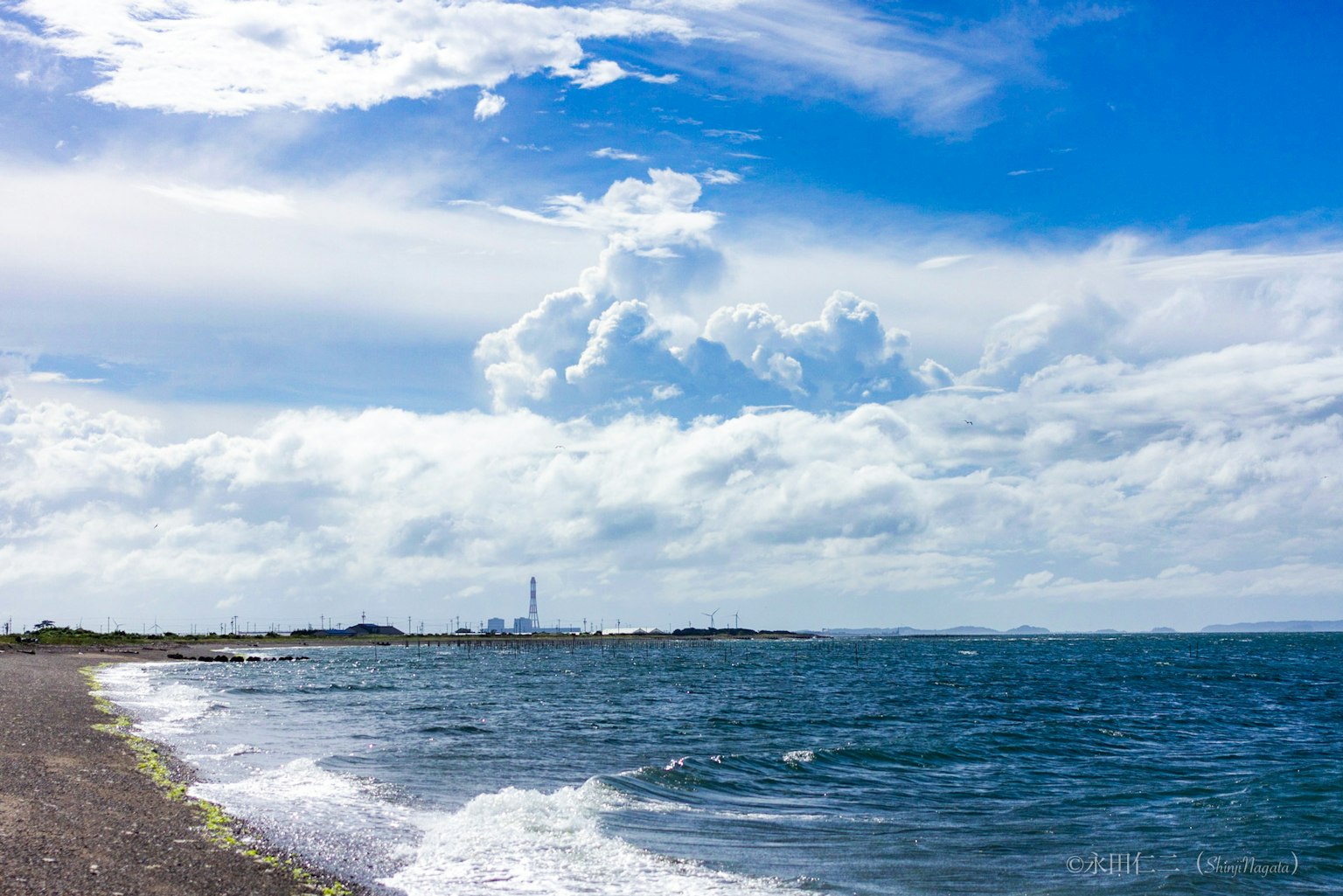 Küstenlandschaft mit blauem Himmel und weißen Wolken