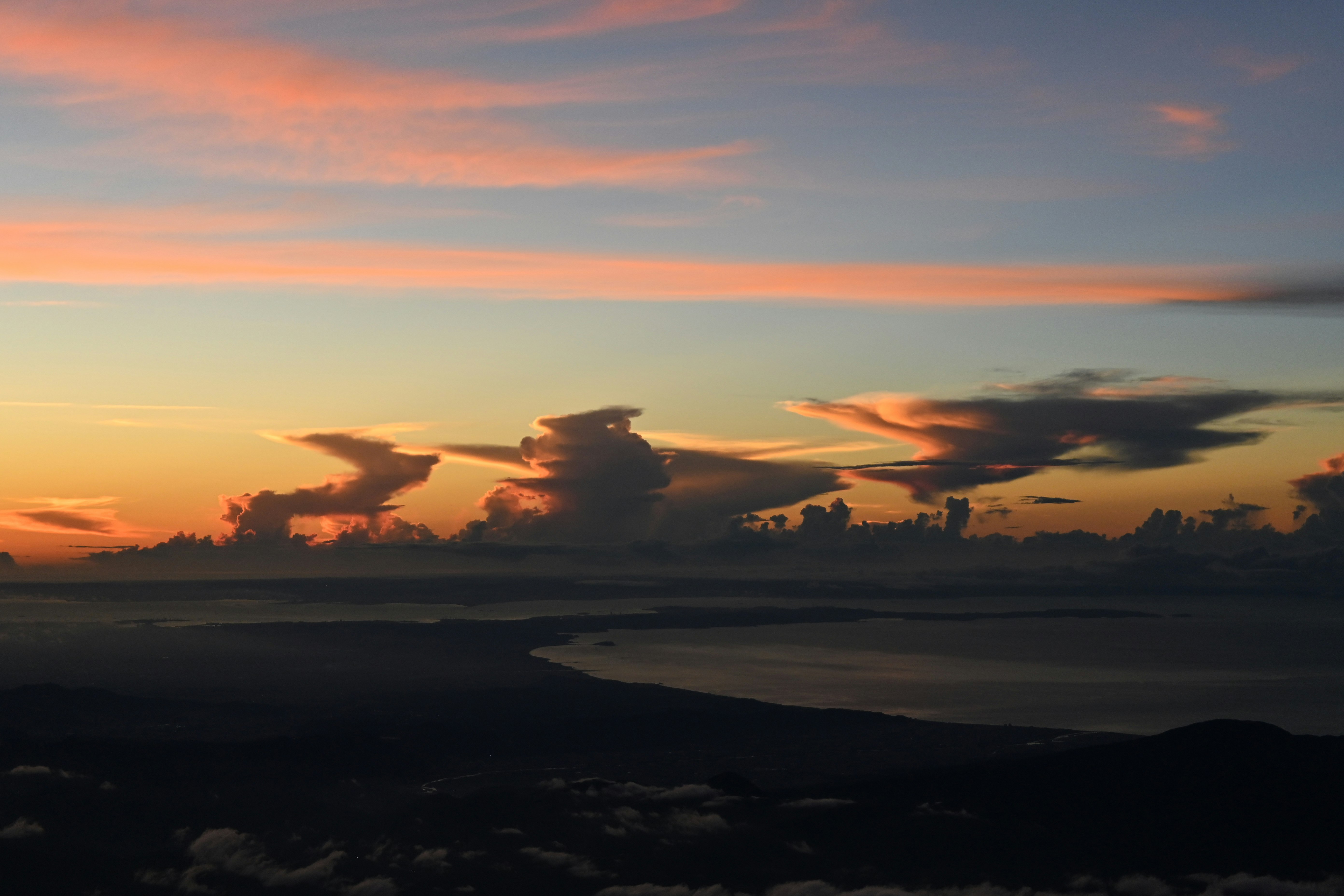 夕焼けの空と雲が広がる海辺の地平線