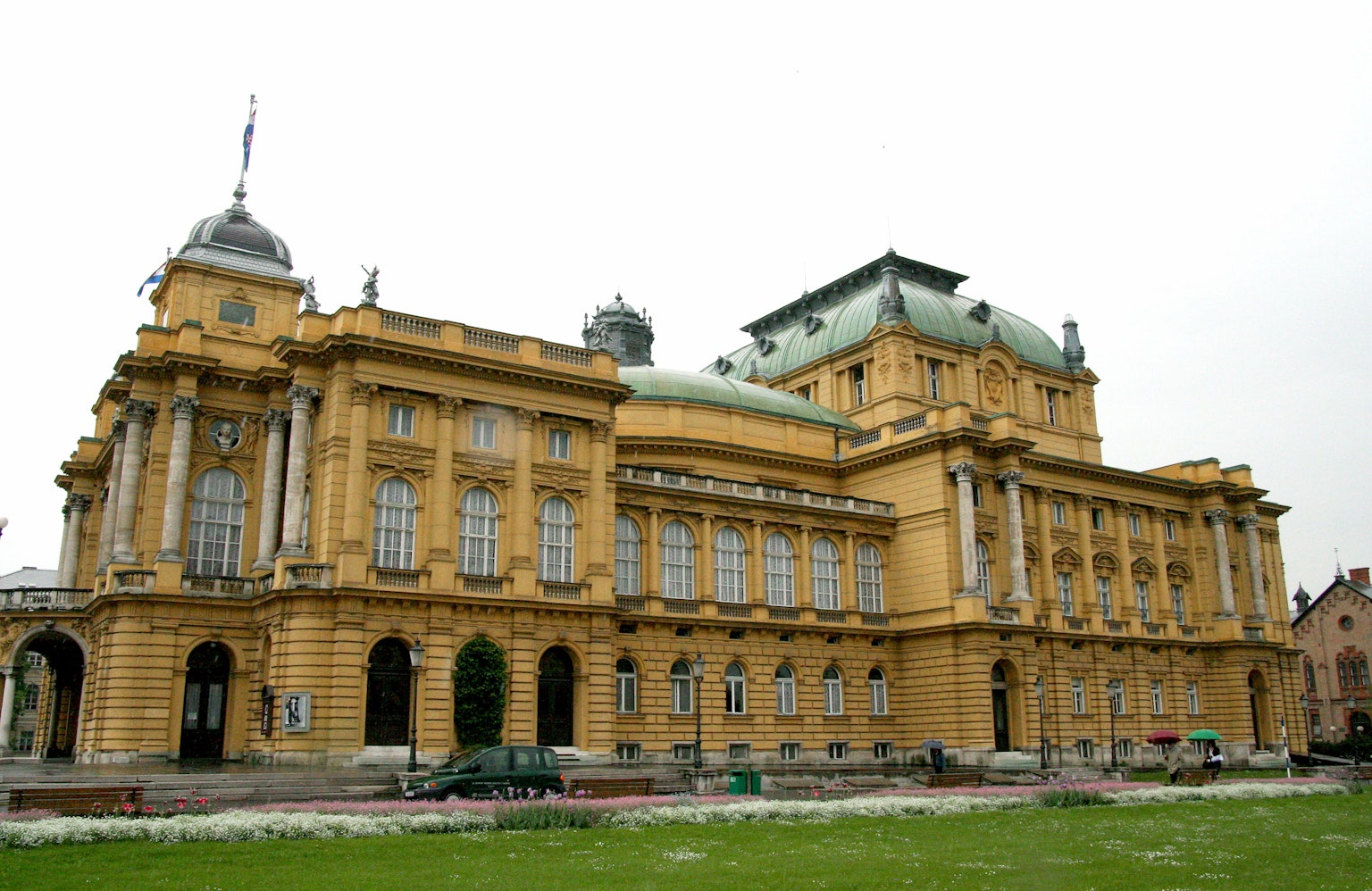 Historic Zagreb opera house exterior featuring yellow facade and elegant dome roof