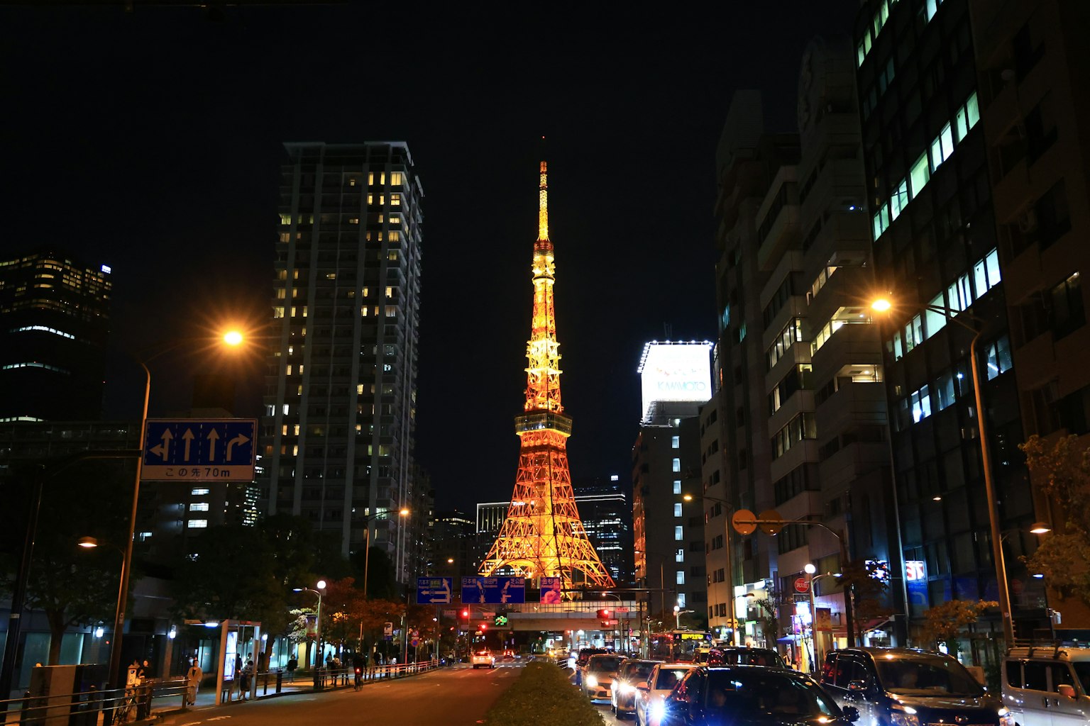 Torre di Tokyo illuminata di notte con edifici circostanti e lampioni