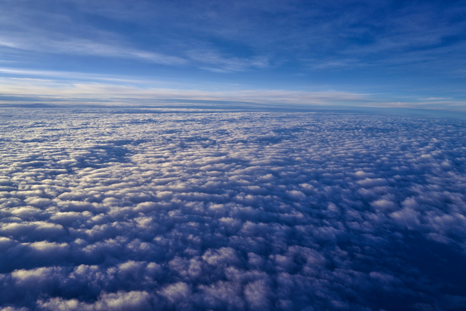 Aerial view of a vast expanse of white clouds under a blue sky