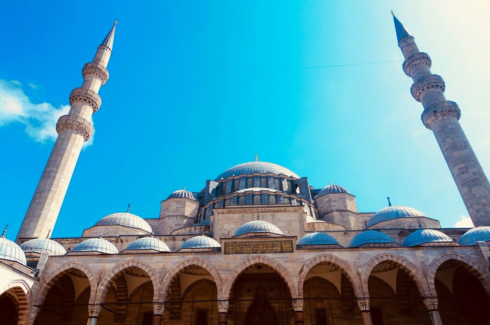 Moscheedomes und Minarette vor blauem Himmel