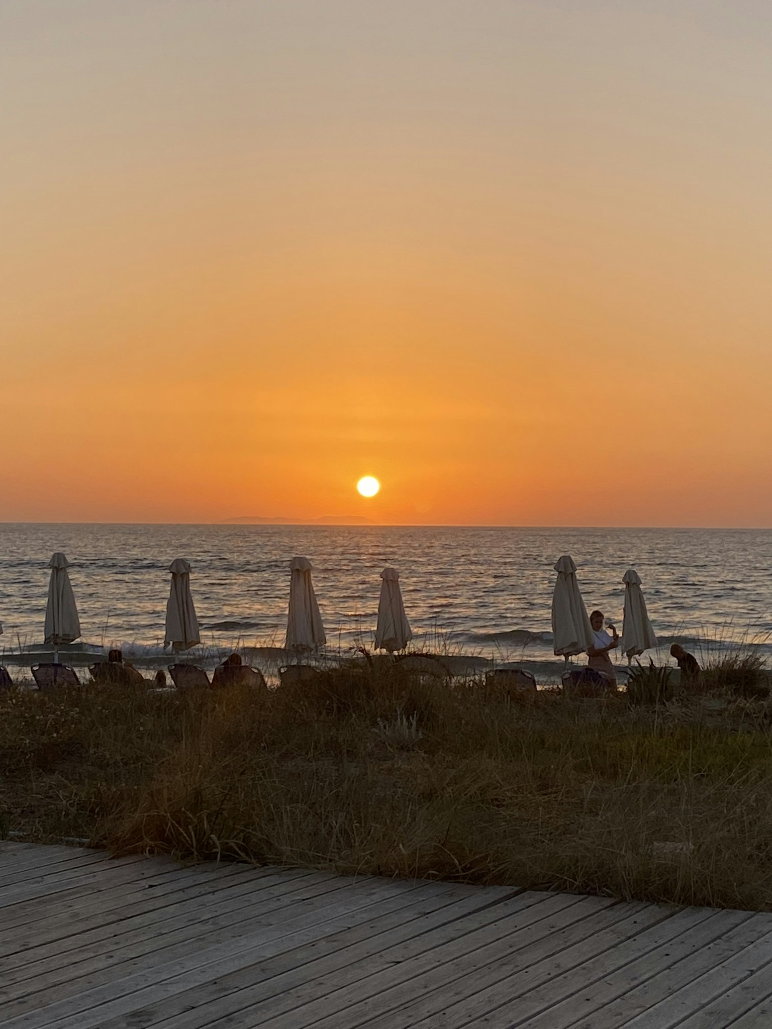 Schöner Sonnenuntergang über dem Ozean mit Strandliegen