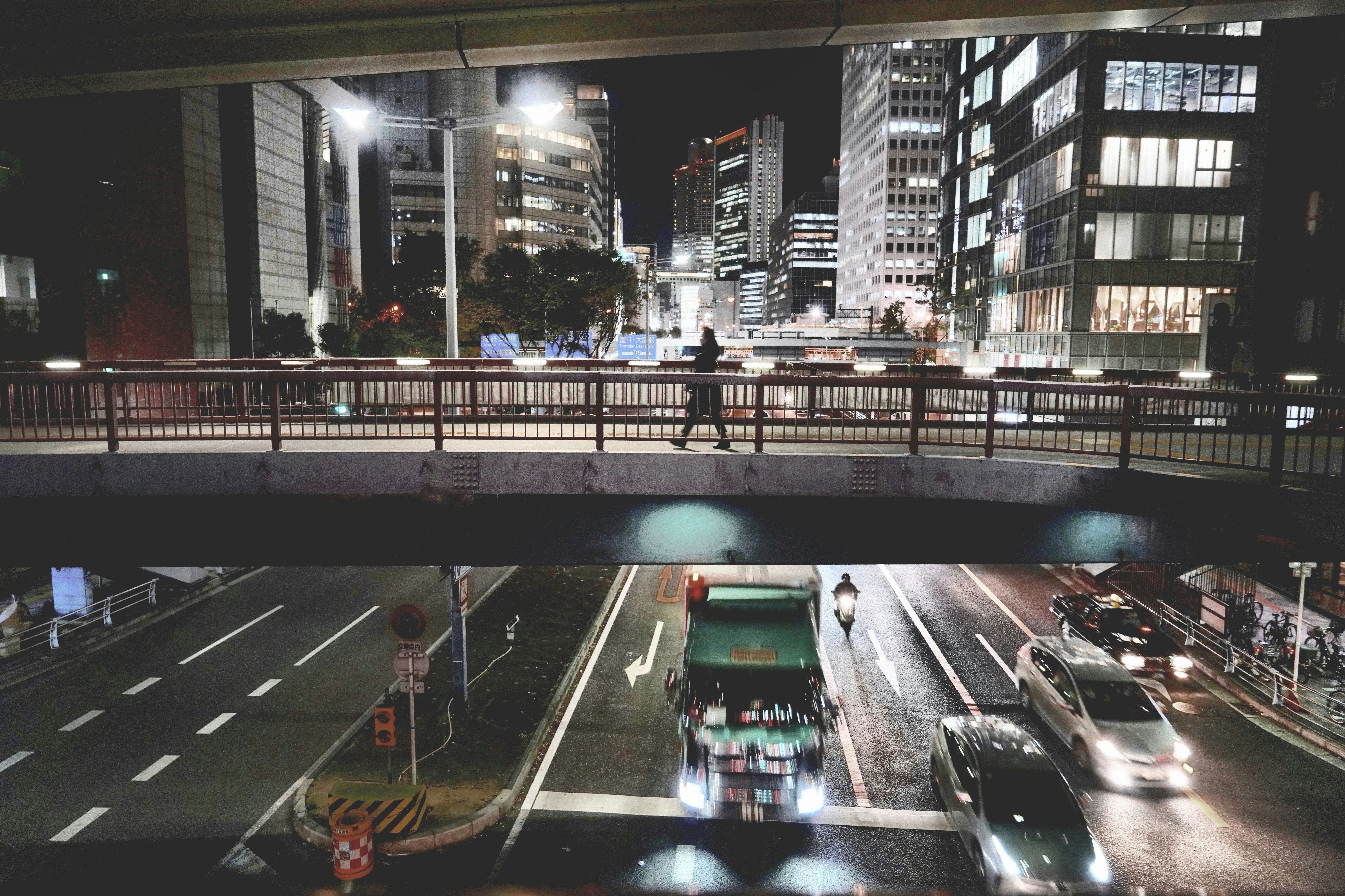 高層ビル街の高架下を走る車と夜景