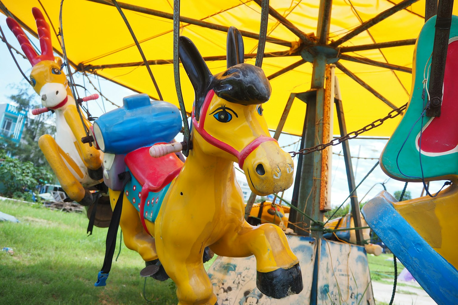 Colorful carousel horses hanging in a playground setting