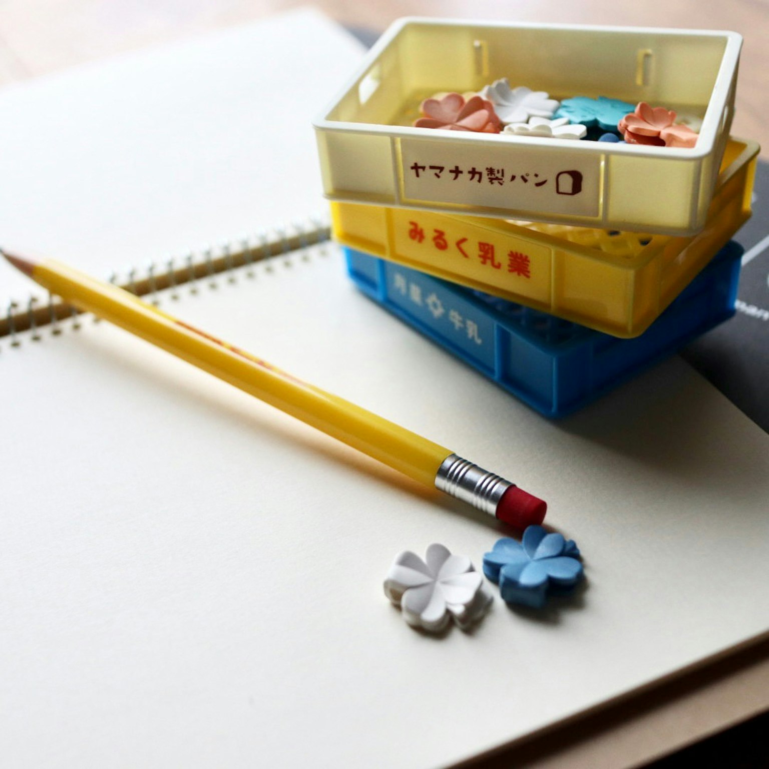Lápiz amarillo y gomas de colores sobre un cuaderno
