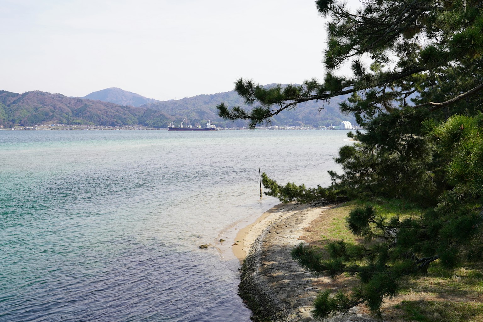 Paesaggio costiero sereno con mare blu e montagne circostanti