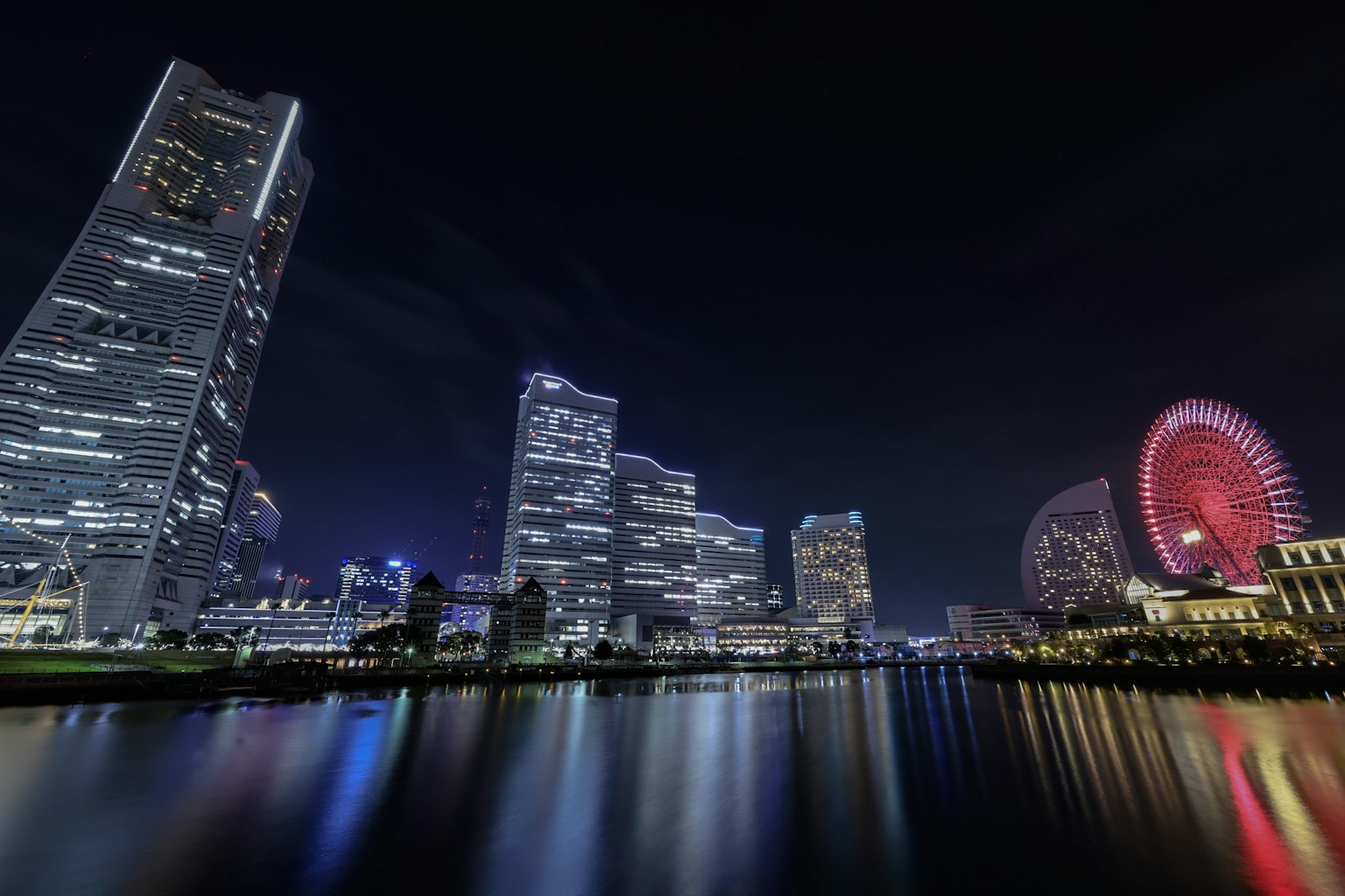 Vista notturna di Yokohama con grattacieli e ruota panoramica
