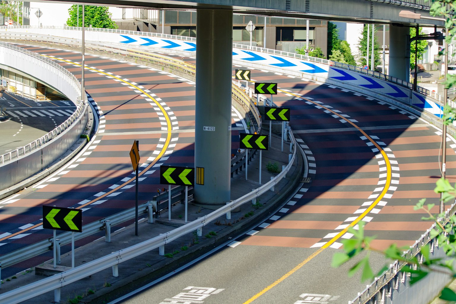 Kurvenreiche Straße mit Verkehrsschildern in einer städtischen Landschaft