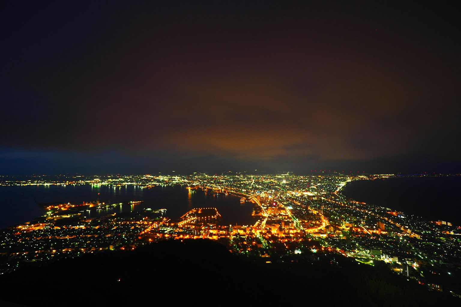 ทิวทัศน์ยามค่ำคืนที่สวยงามของเมืองและทะเล