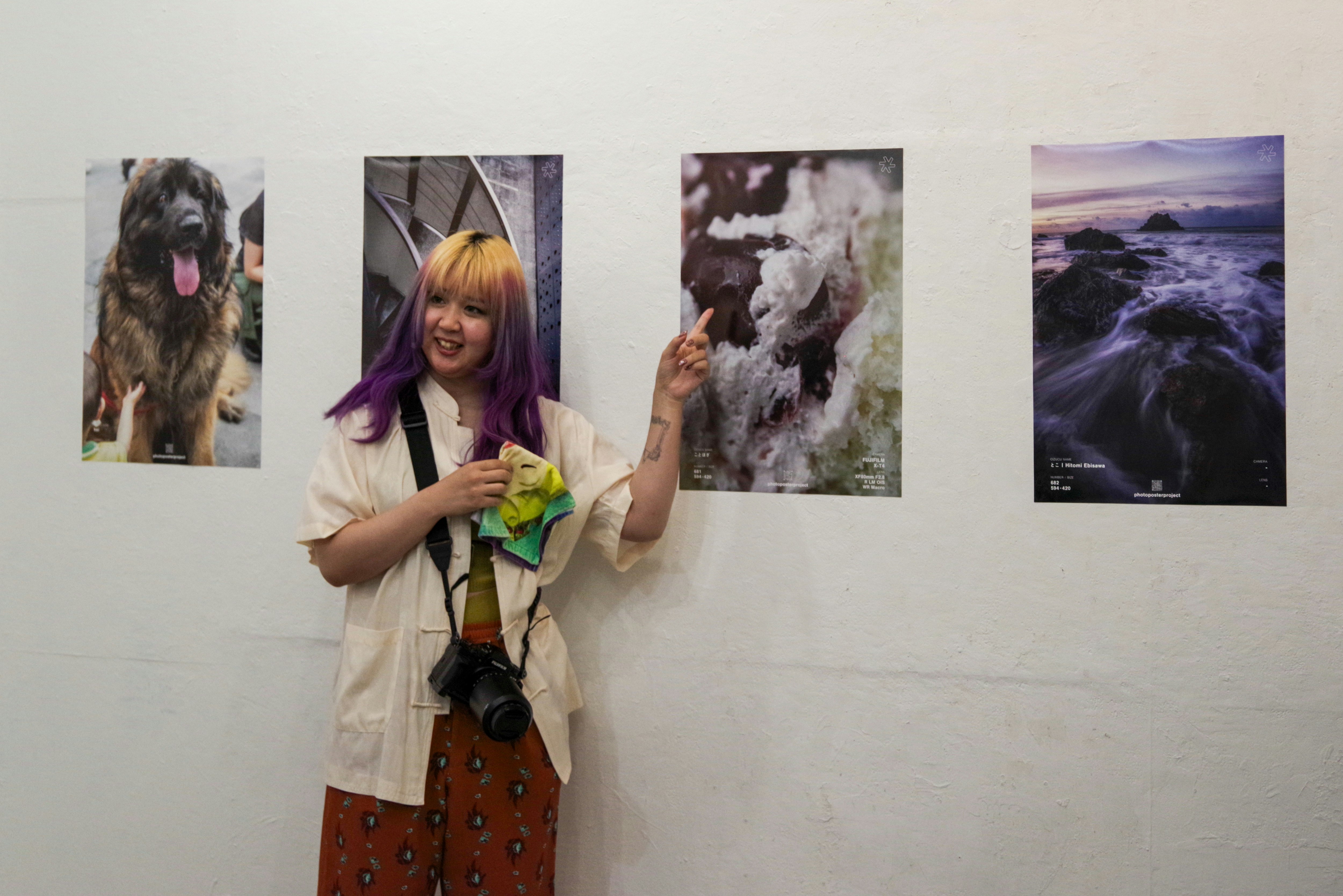 東京のギャラリーで犬と写真作品を前にする女性
