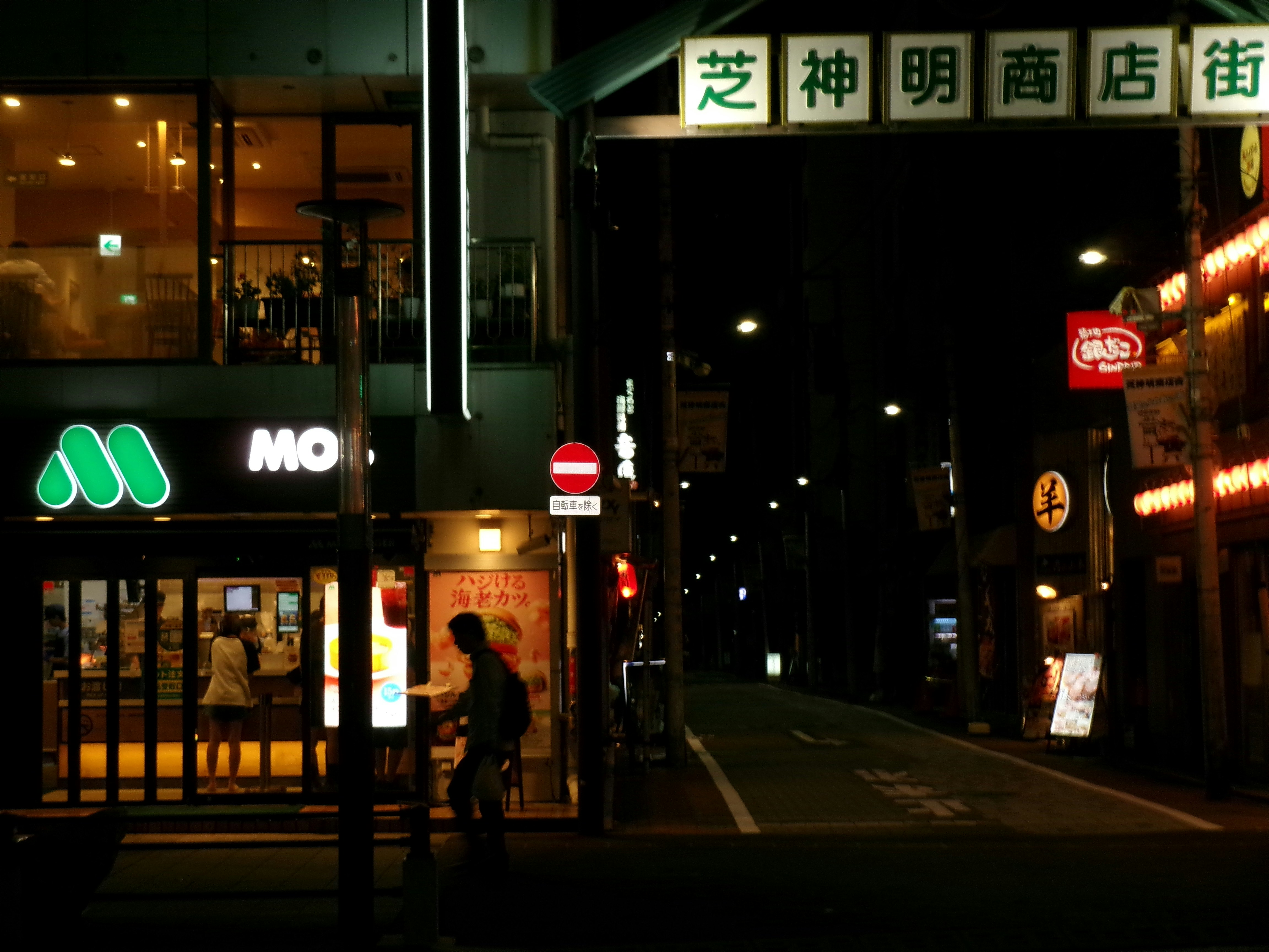 浜松町の夜の商店街で歩く人のシルエット