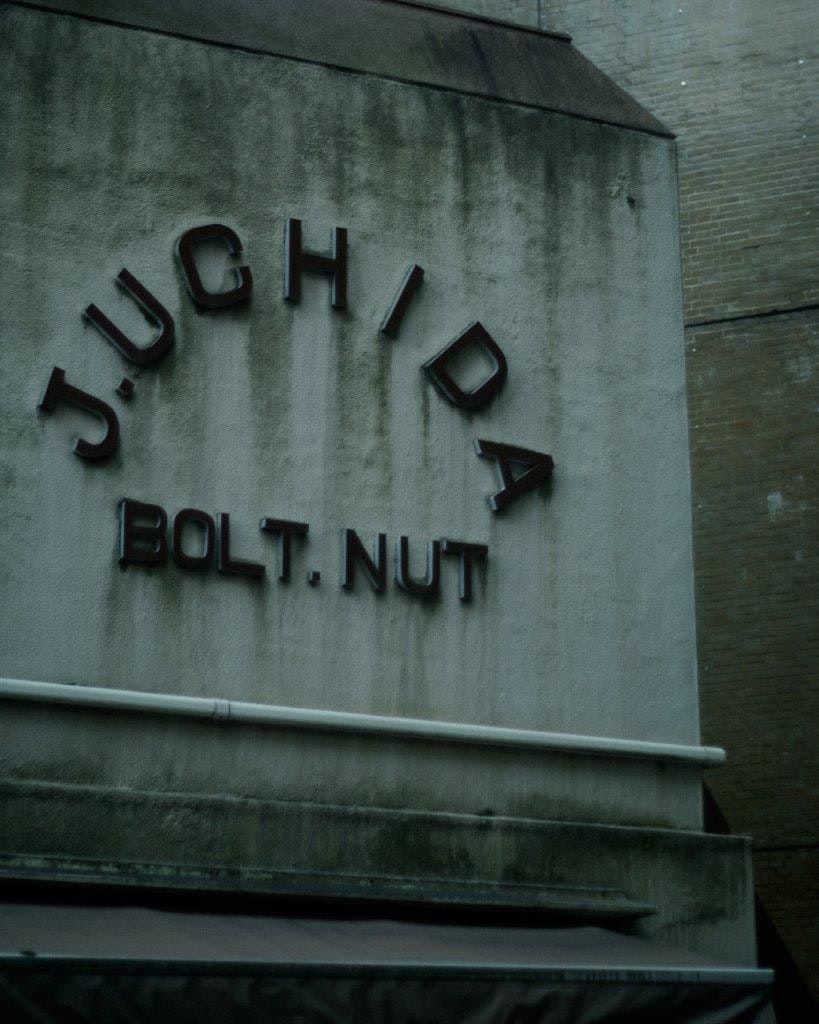 壁面に大きく刻まれたJYCHYDAの文字とBOLT NUT