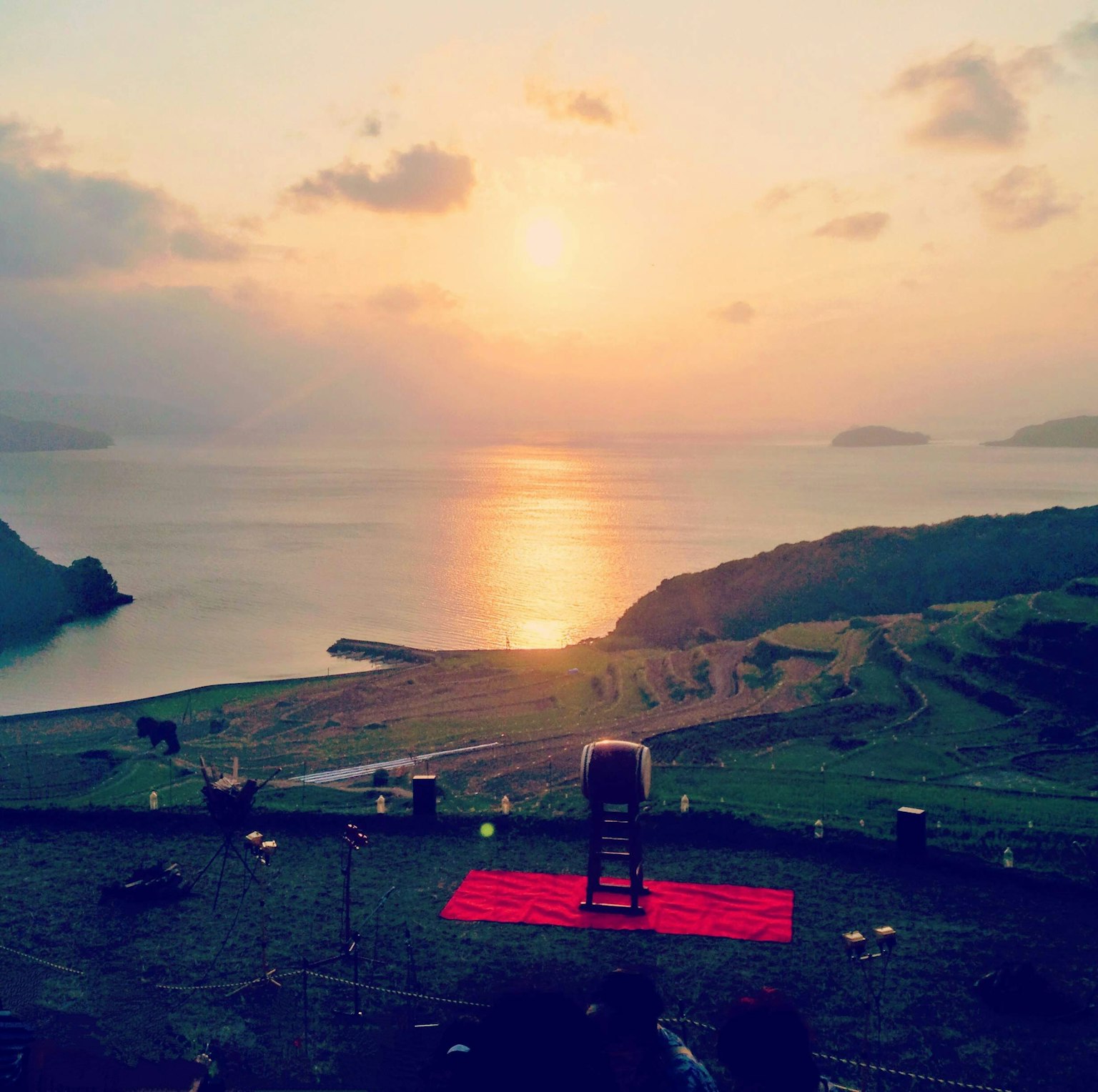 美麗的夕陽映照在海面上，紅色墊子上的椅子