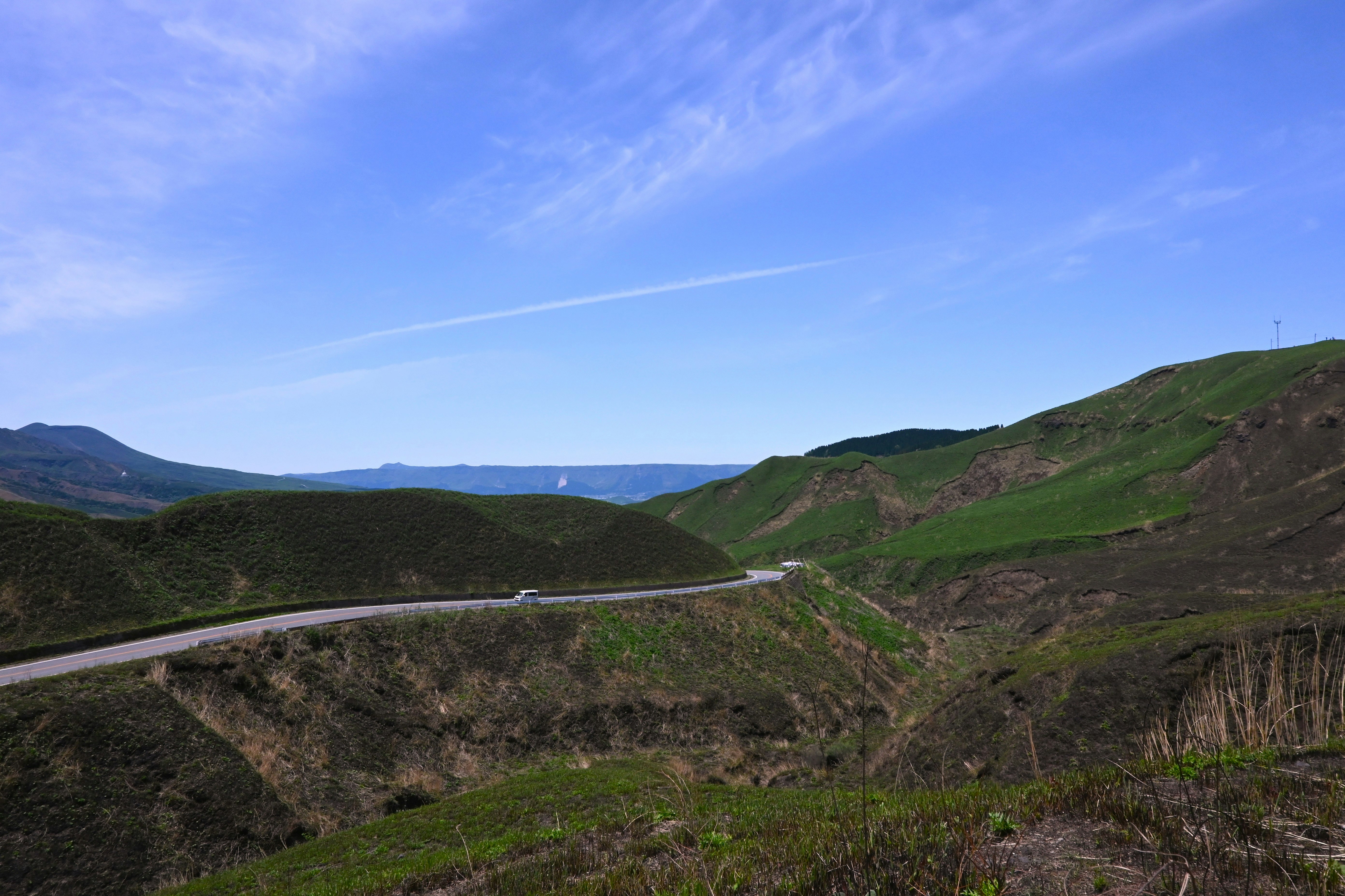 箱石峠の山稜と曲がりくねった道路、遠くに海の眺め