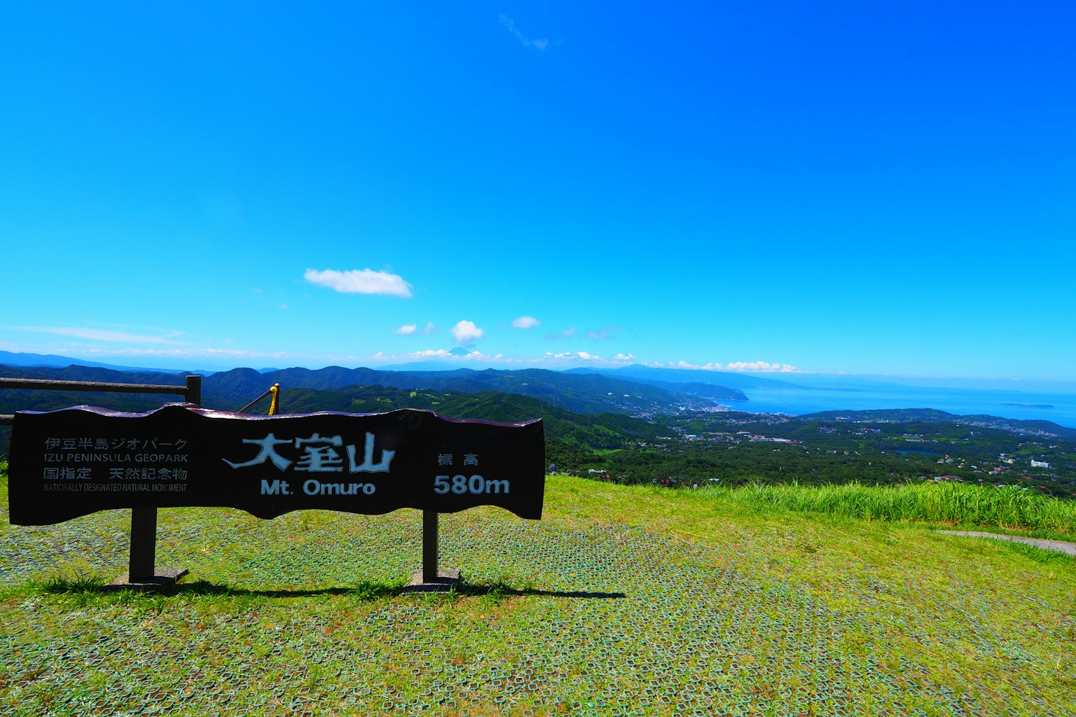 Pemandangan dari puncak Gunung Chirus dengan langit biru dan lautan di latar belakang