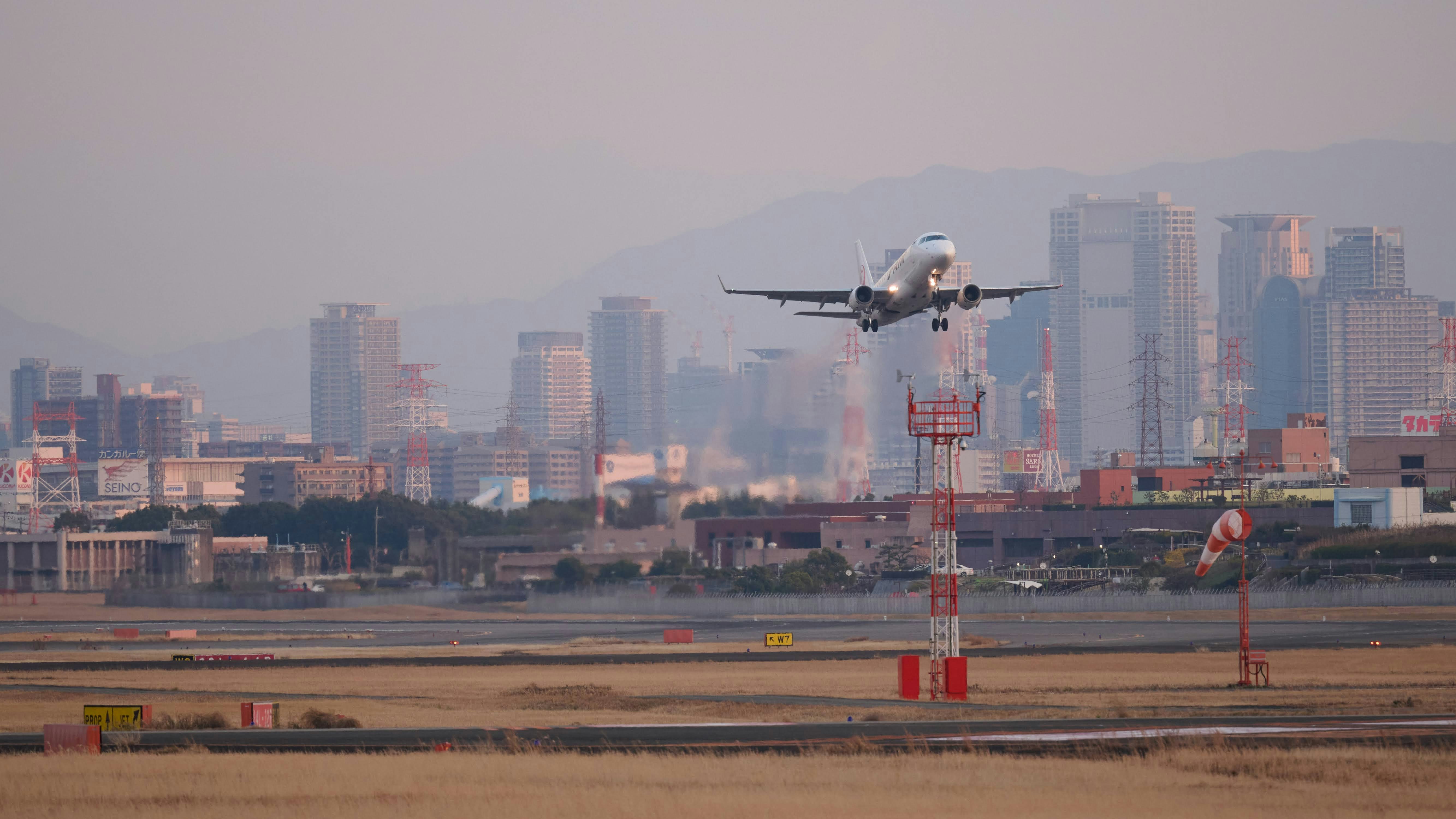 滑走路を離着陸する旅客機と都市のスカイライン