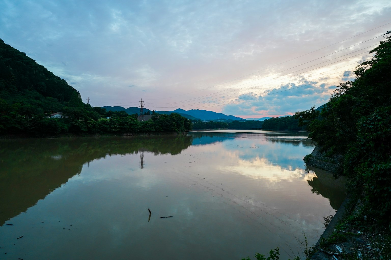 Paysage de rivière tranquille et de montagnes se reflétant dans le ciel du soir