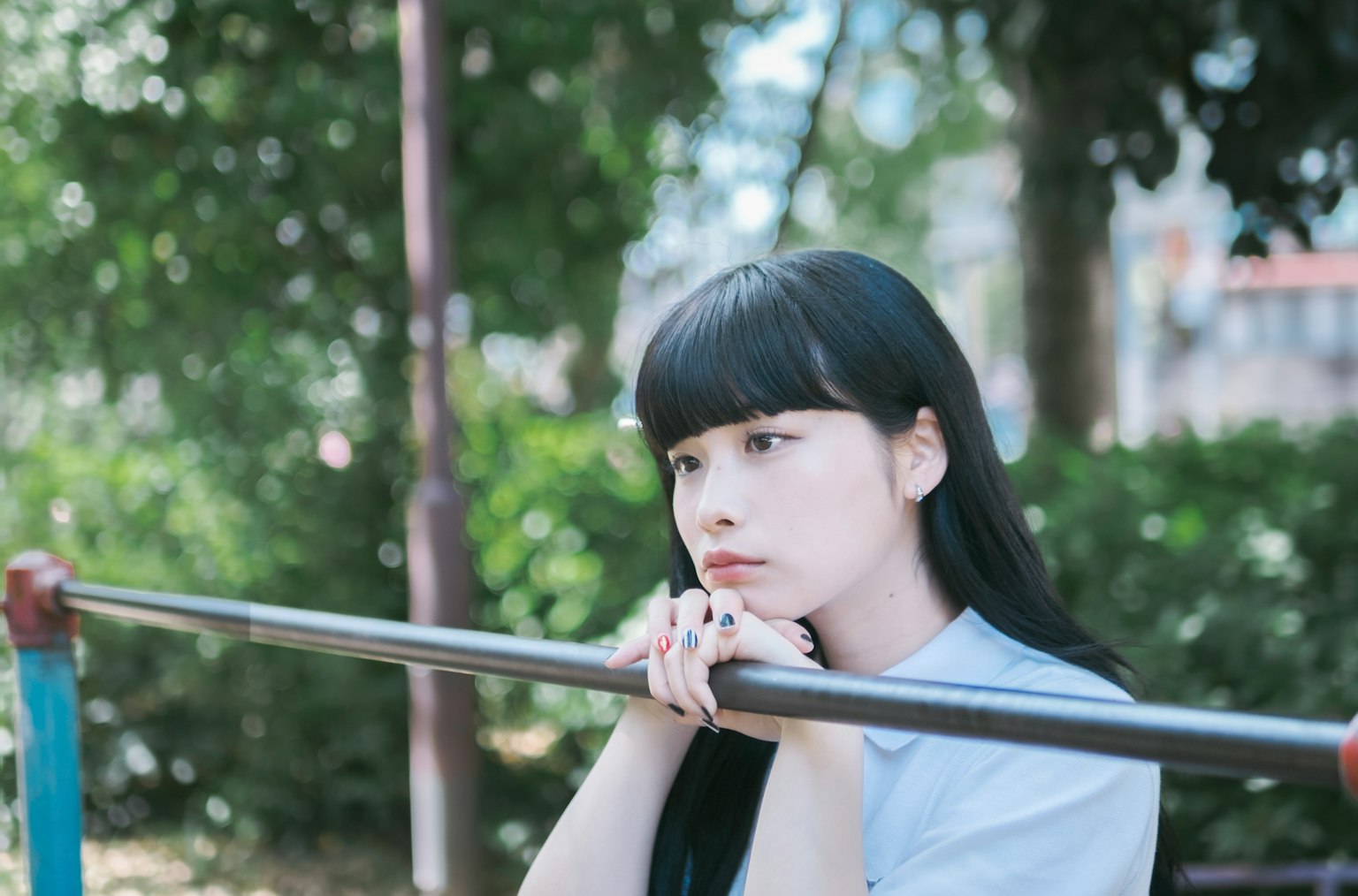 公園の遊具で考え込む少女の横顔