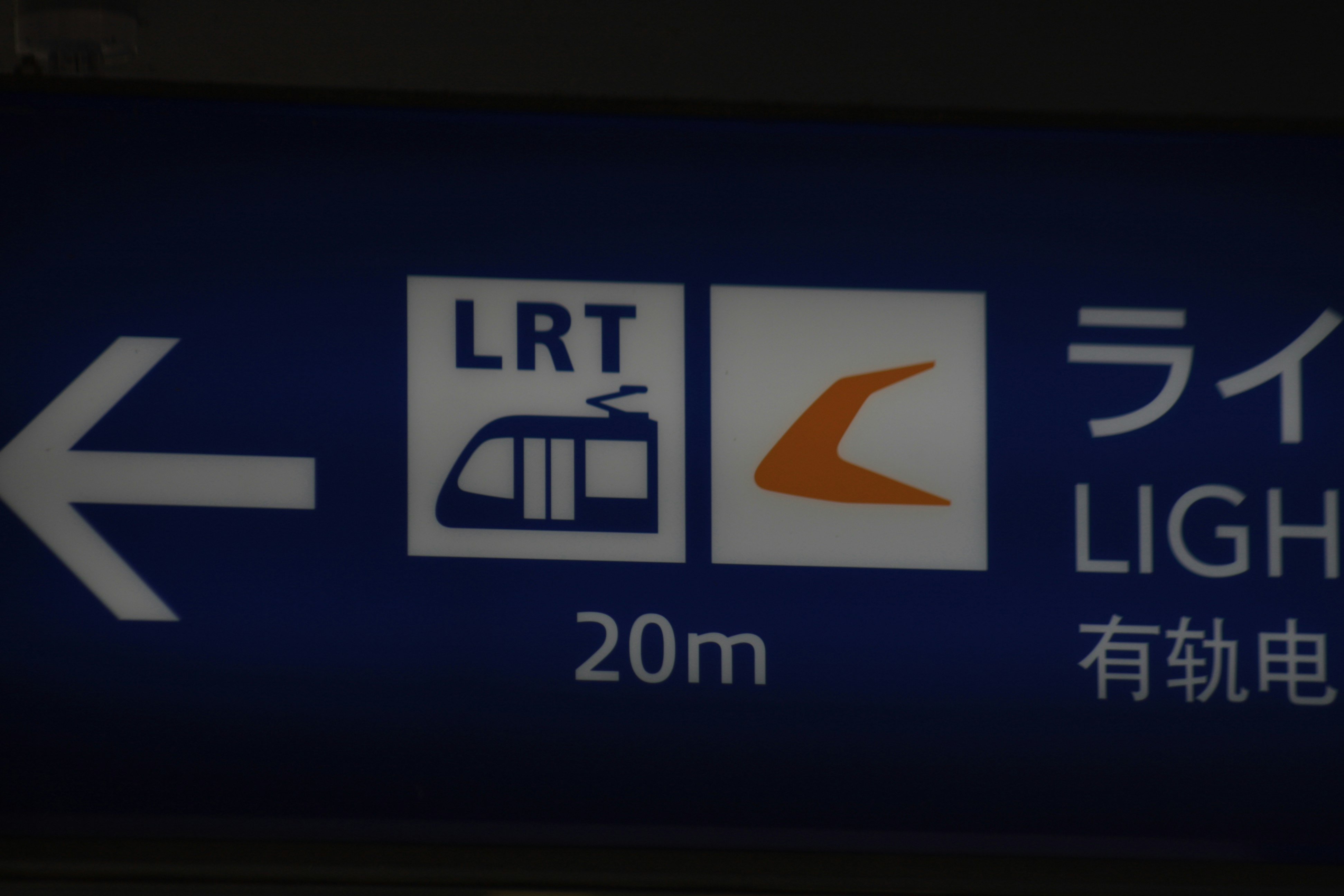 駅のホームにある案内サインと距離表示のある青い照明の看板