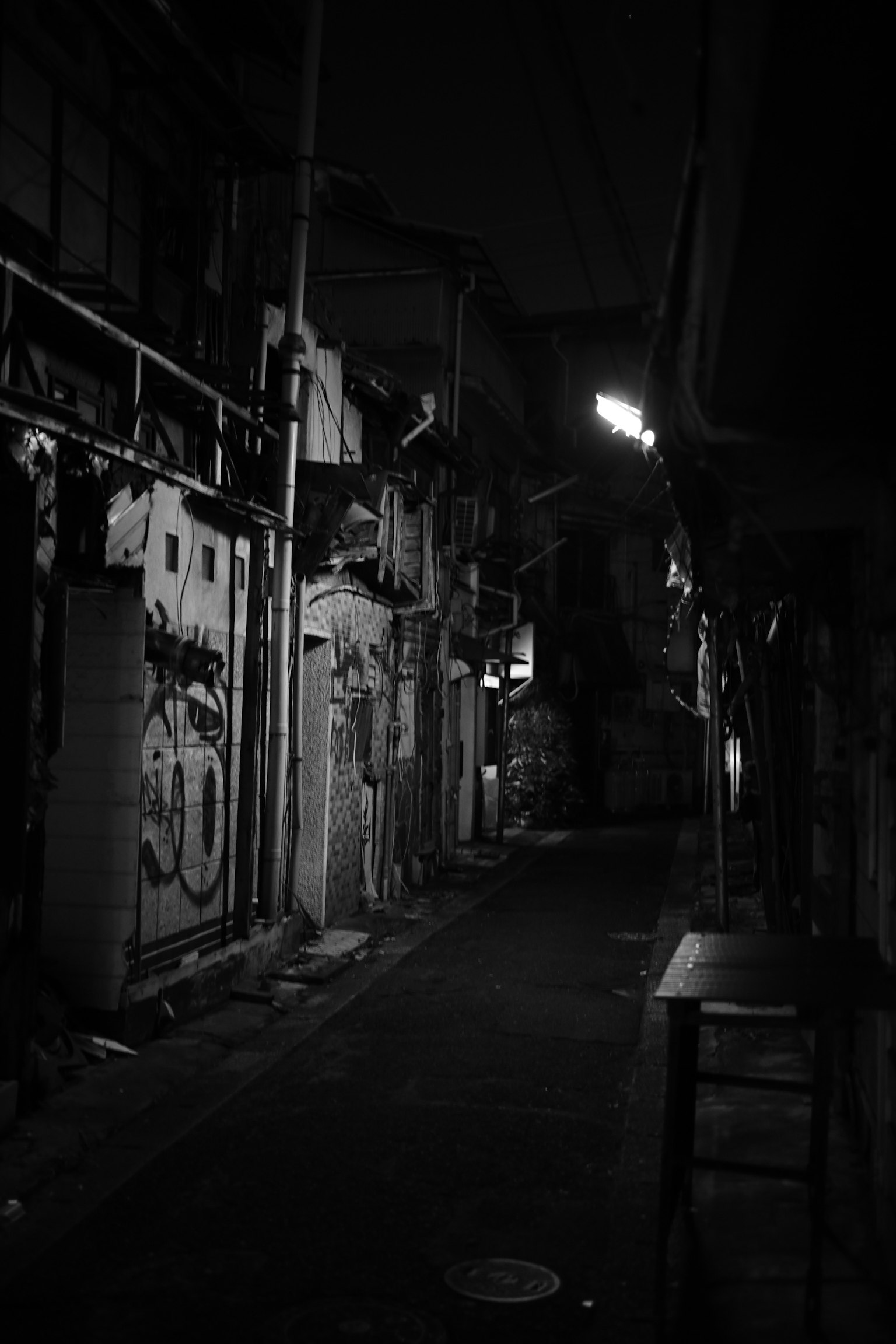 Callejón oscuro con edificios antiguos y graffiti