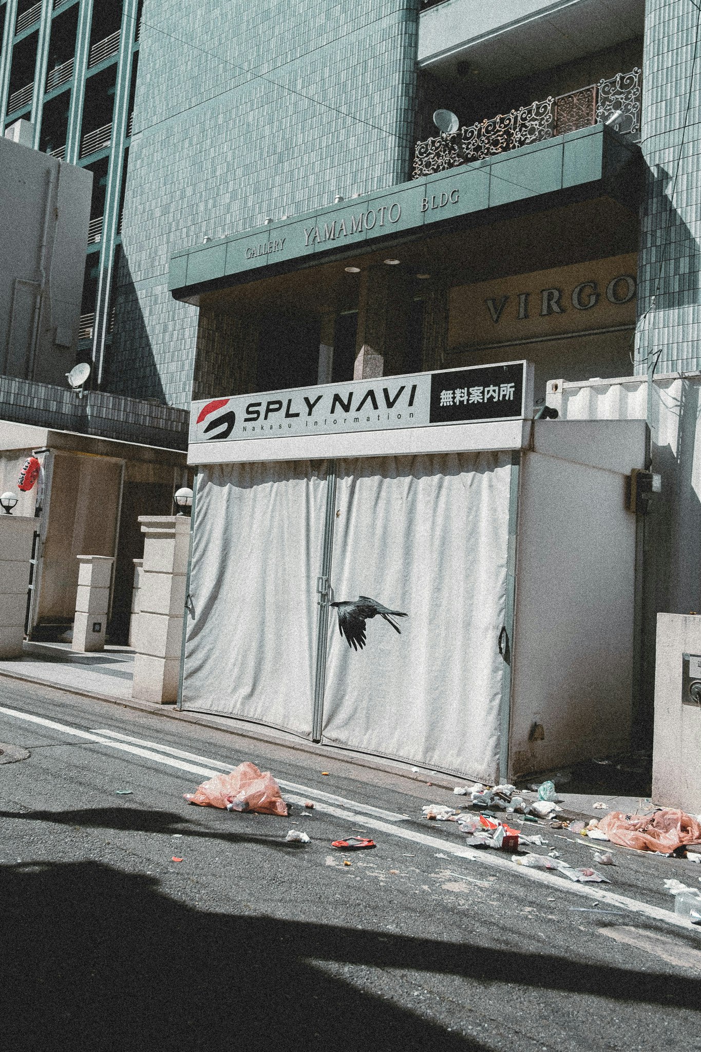「SPLY NAVI」看板のある路上で散乱した物