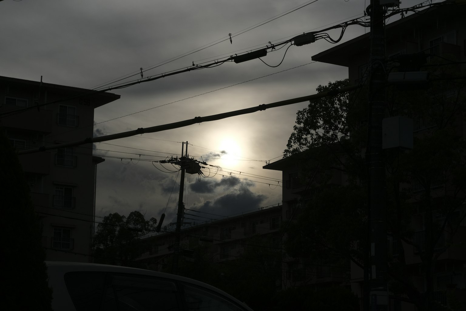 Silhouette of buildings against a cloudy sunset sky