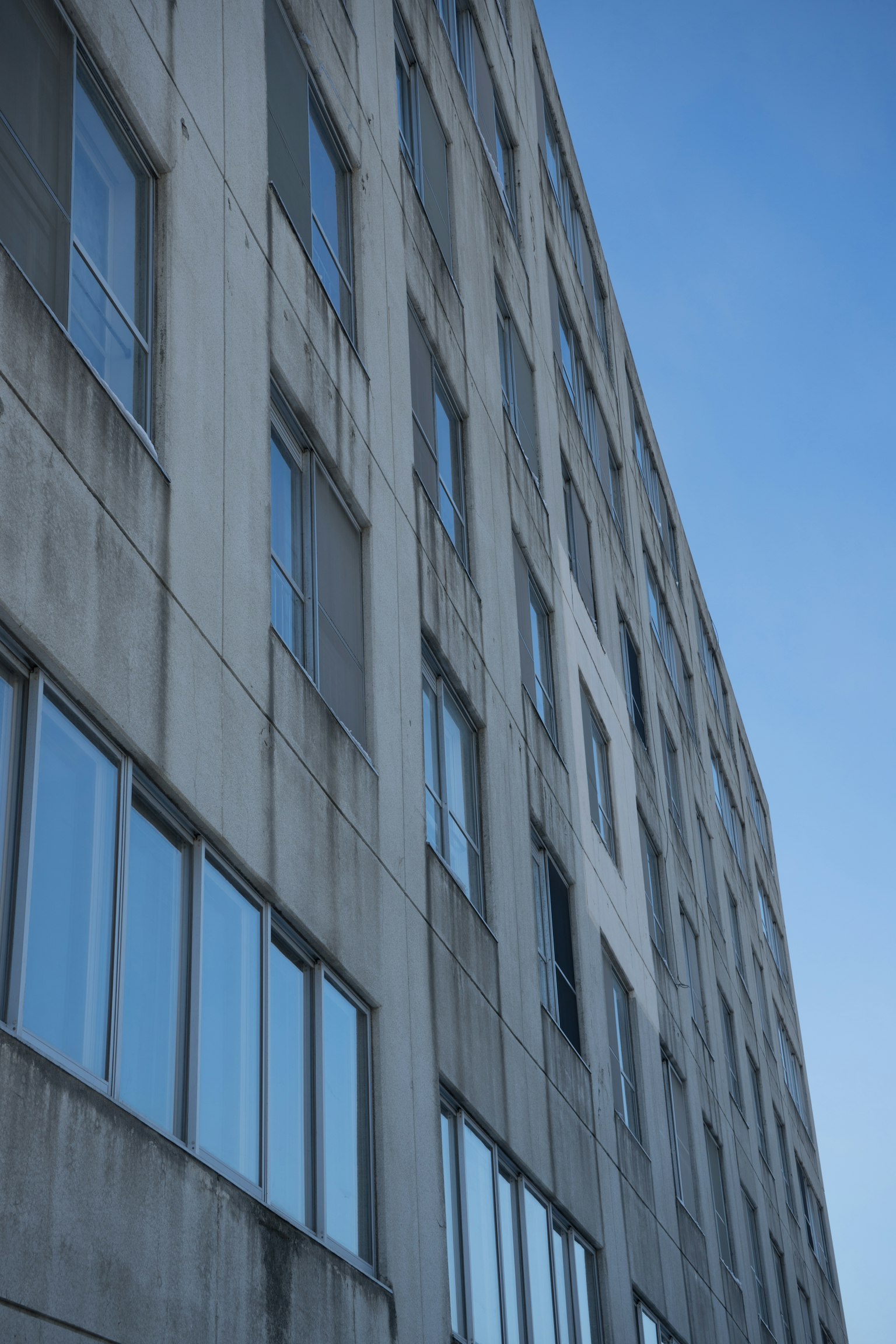 Diagonale Ansicht eines Betongebäudes mit großen Fenstern