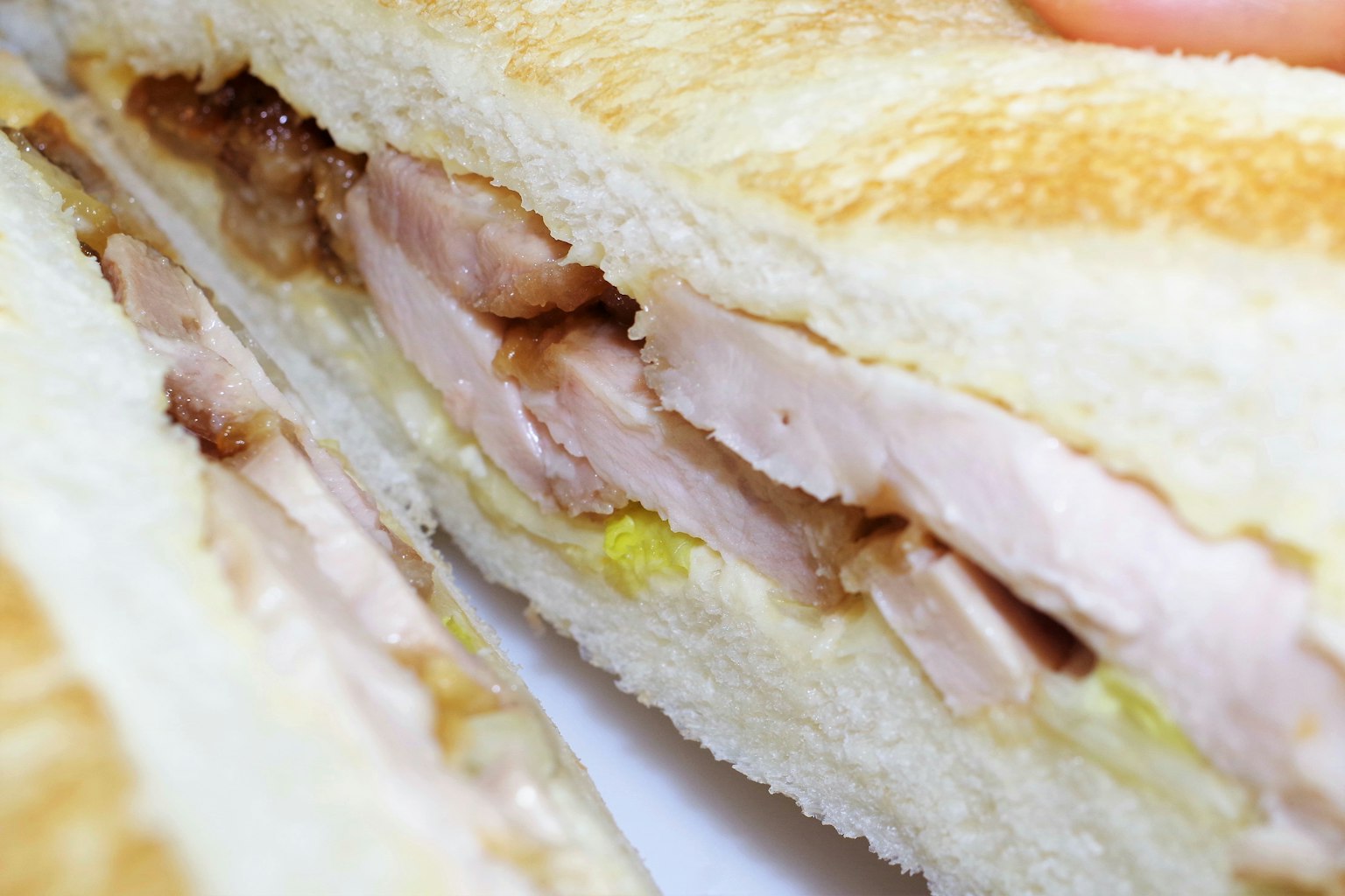 Un panino con pollo affettato e cetrioli sottaceto tra pane tostato