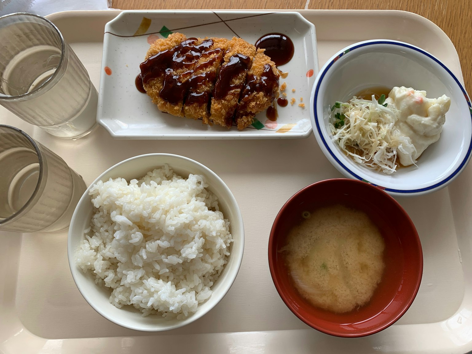 托盘上的一顿饭包括米饭味噌汤可乐饼沙拉