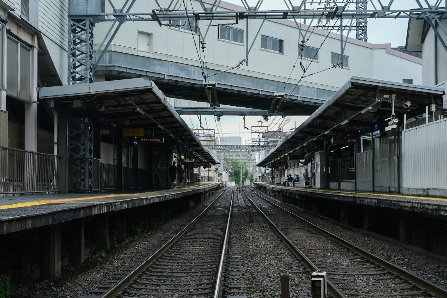Vista delle piattaforme della stazione e dei binari con struttura sopraelevata