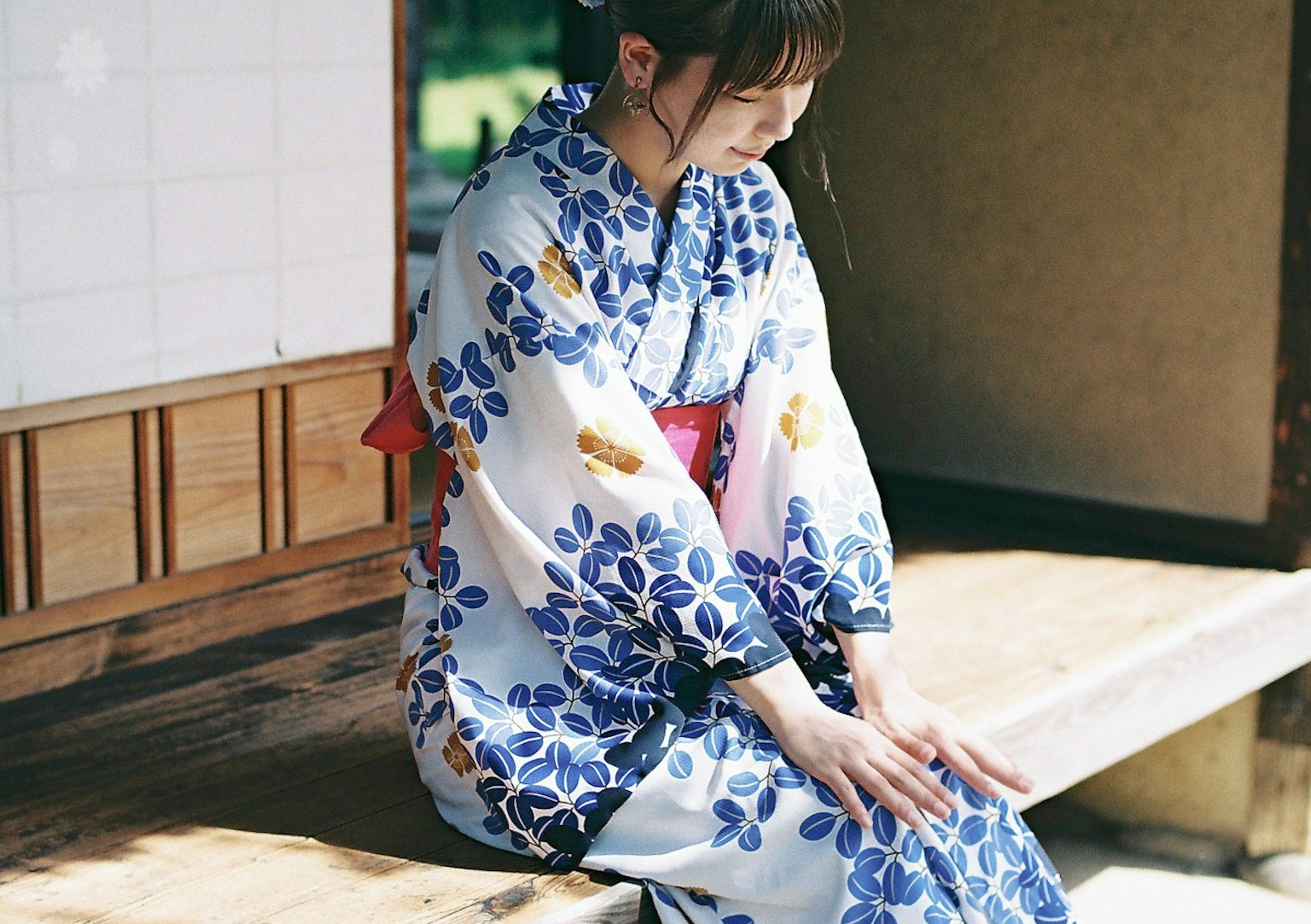 穿著藍色花卉浴衣的女性坐在木凳上